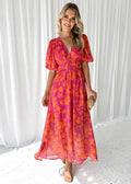 Woman modeling vibrant floral midi dress with V-neck and puff sleeves.