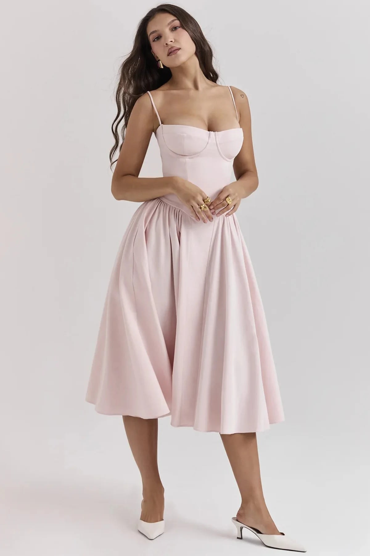 Woman wearing a bustier midi dress with spaghetti straps and A-line skirt.