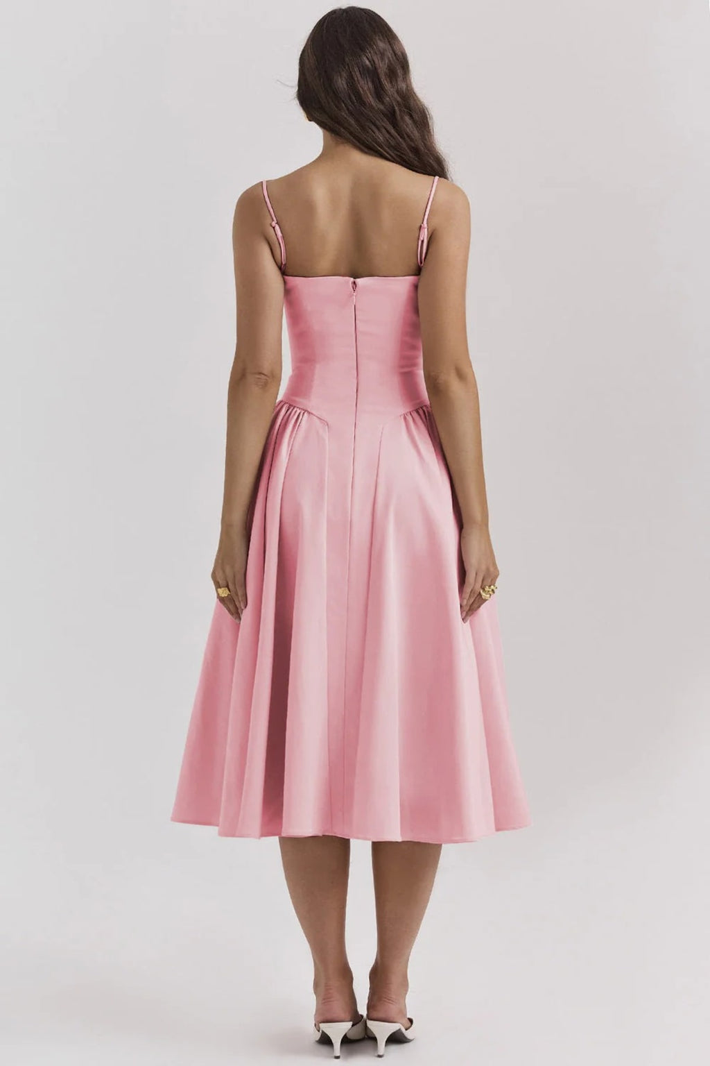 Woman wearing a bustier midi dress with spaghetti straps and A-line skirt.