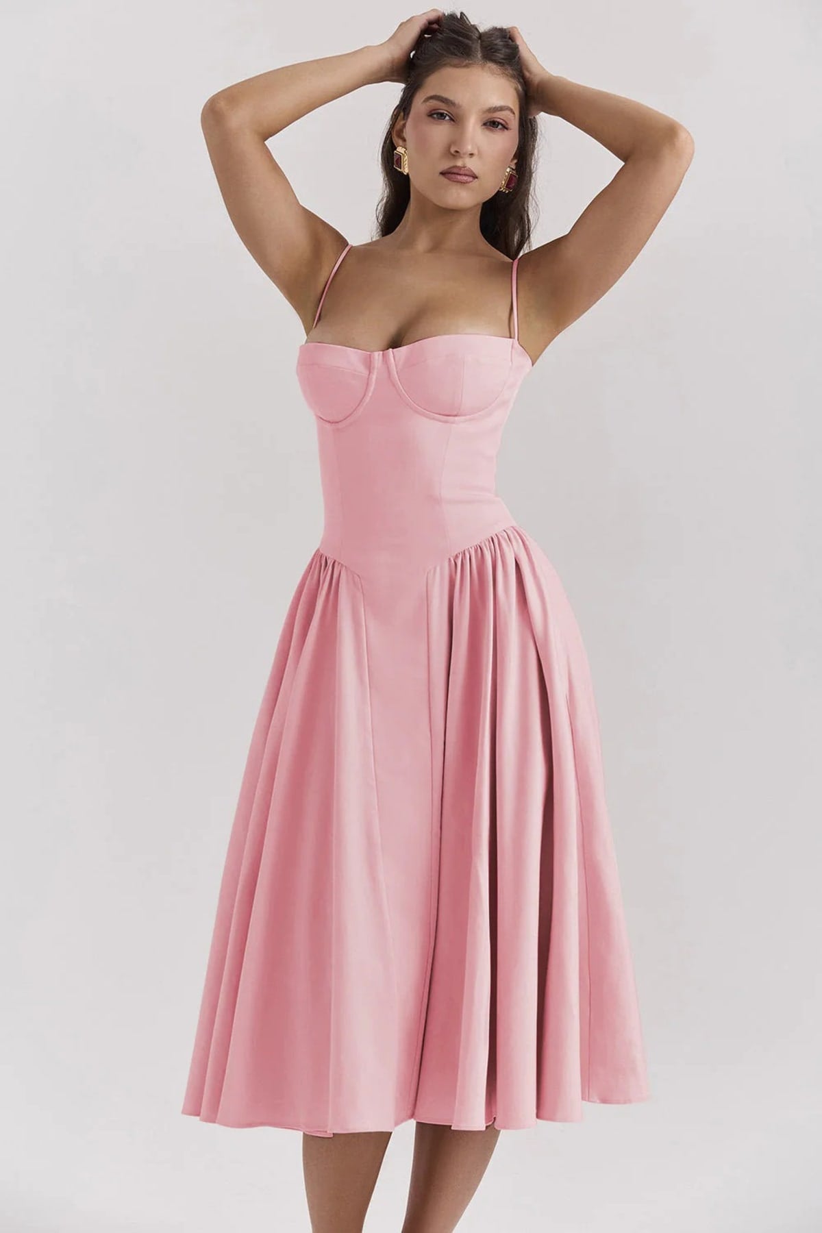 Woman wearing a bustier midi dress with spaghetti straps and A-line skirt.