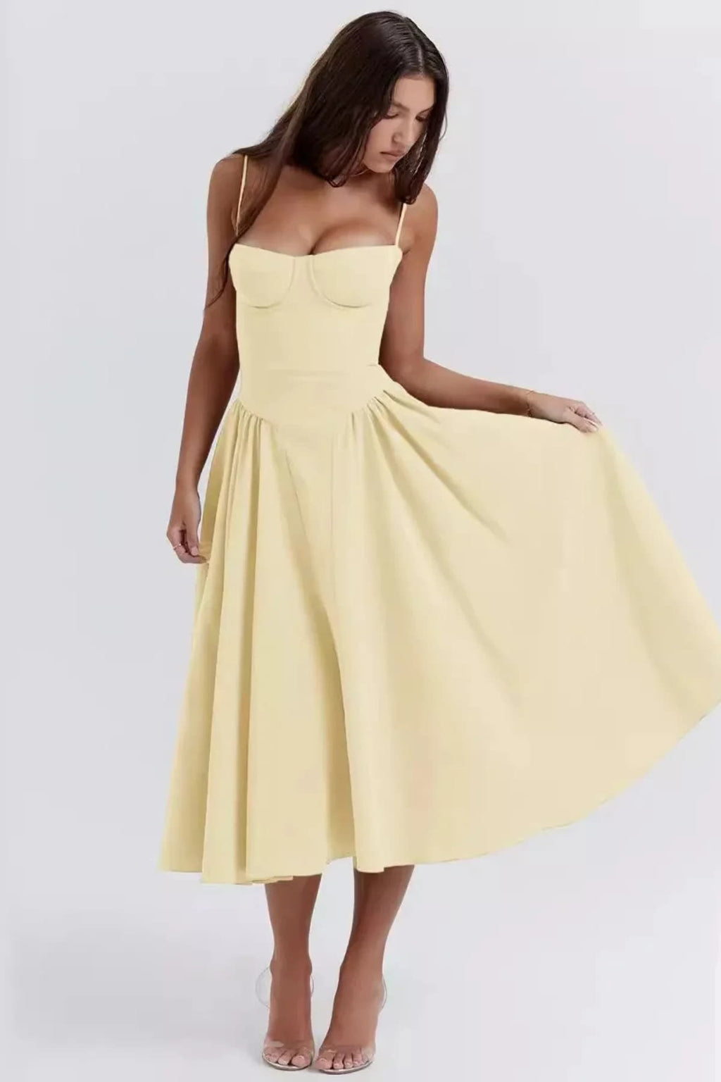 Woman wearing a bustier midi dress with spaghetti straps and A-line skirt.