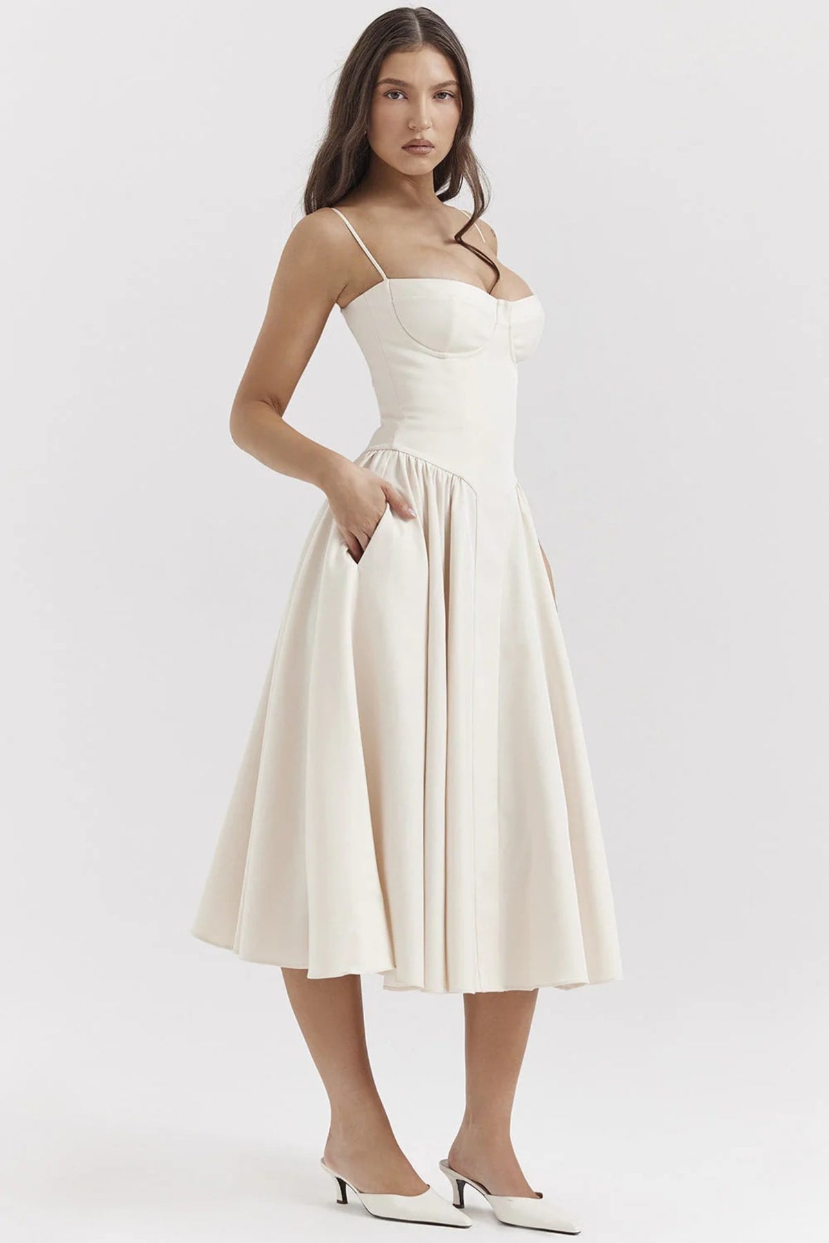 Woman wearing a bustier midi dress with spaghetti straps and A-line skirt.