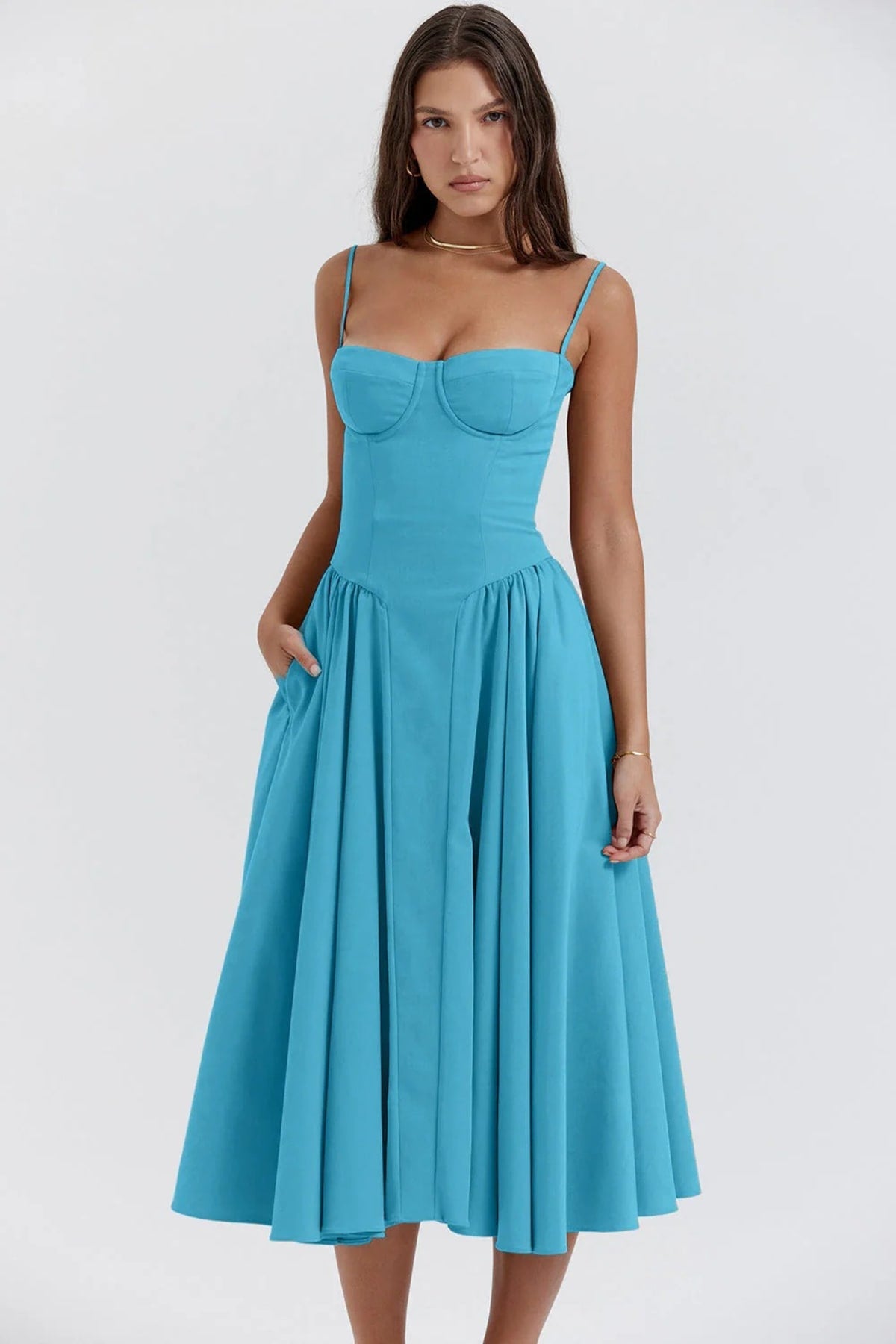 Woman wearing a bustier midi dress with spaghetti straps and A-line skirt.