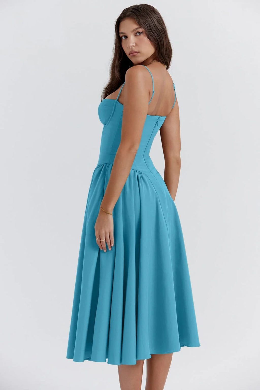 Woman wearing a bustier midi dress with spaghetti straps and A-line skirt.
