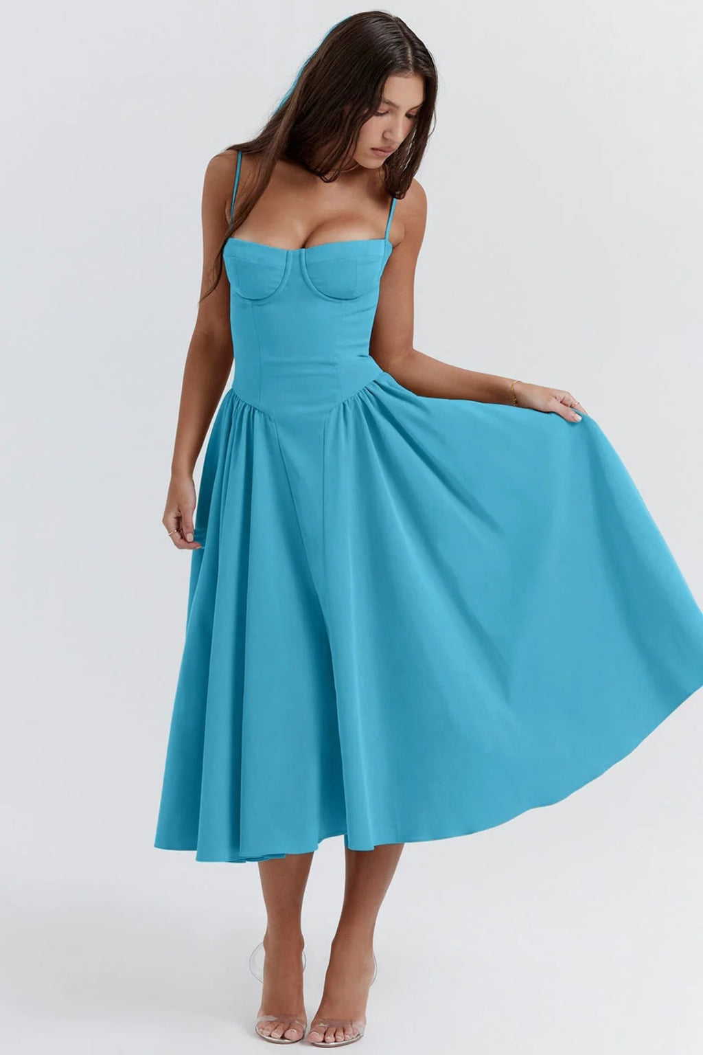 Woman wearing a bustier midi dress with spaghetti straps and A-line skirt.