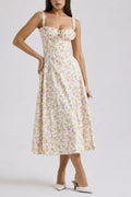 Woman wearing white midi dress with floral pattern and sweetheart neckline.
