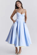 Woman in a midi dress with sweetheart neckline, full skirt, and spaghetti straps.