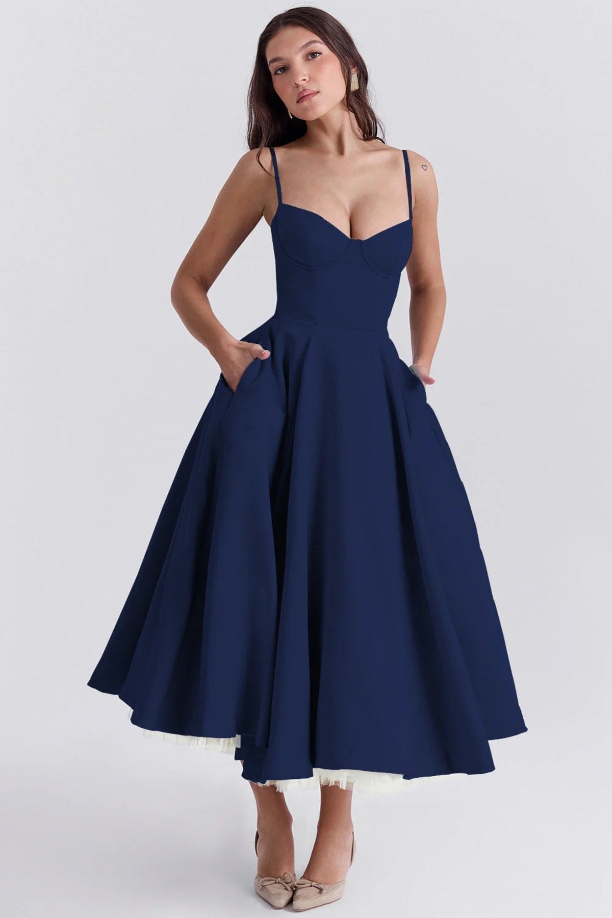 Woman in a midi dress with sweetheart neckline, full skirt, and spaghetti straps.