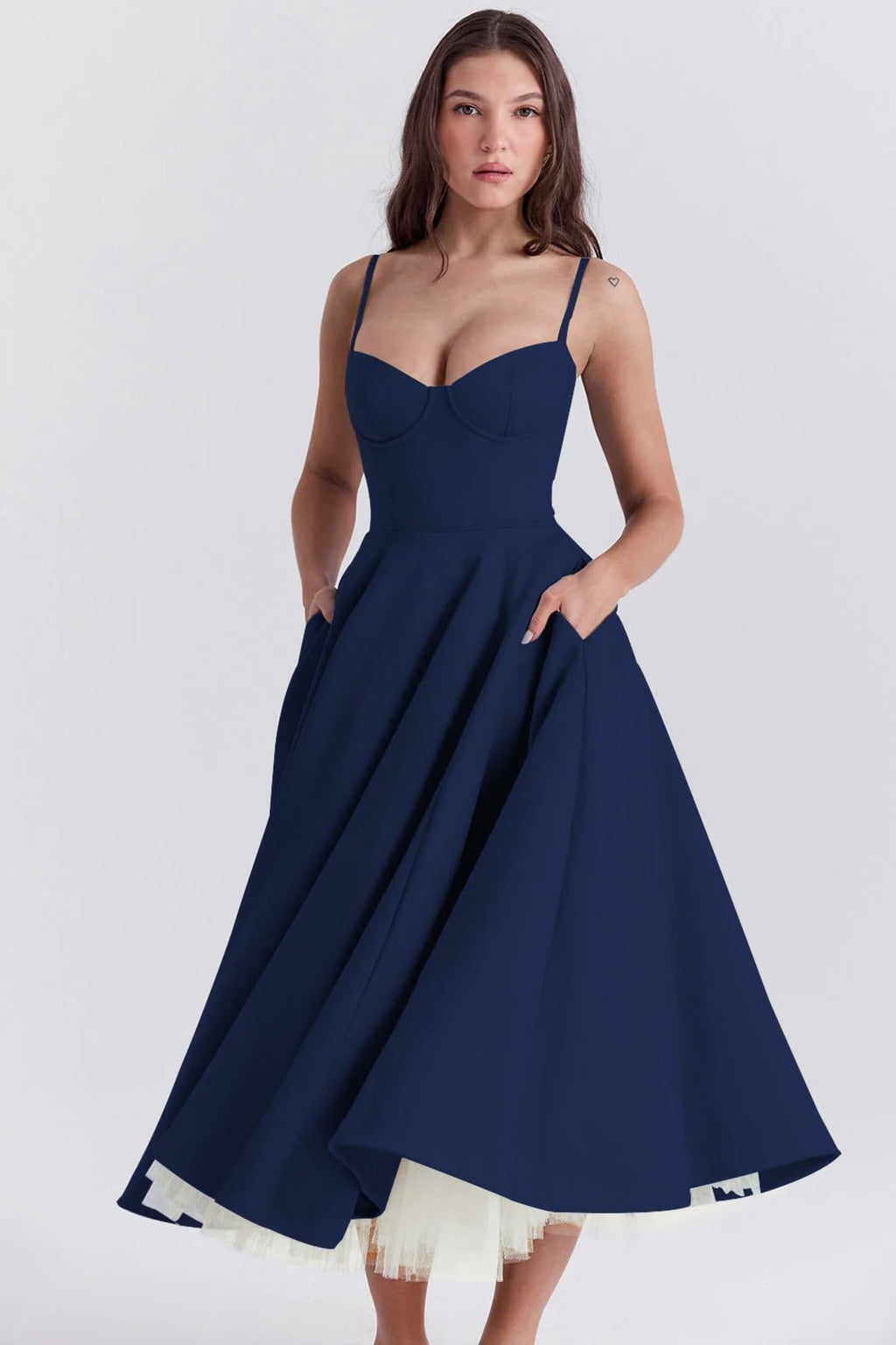 Woman in a midi dress with sweetheart neckline, full skirt, and spaghetti straps.