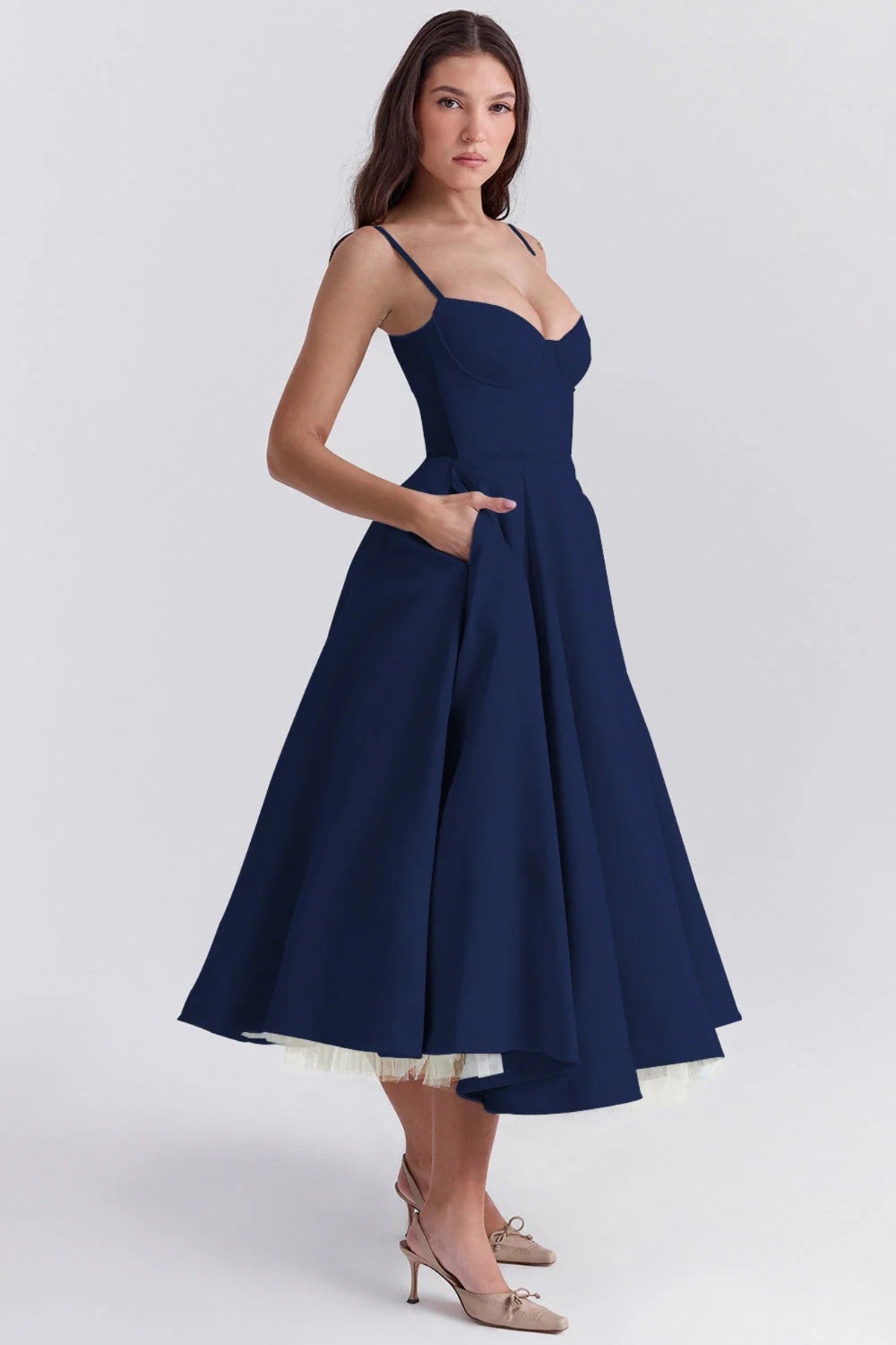 Woman in a midi dress with sweetheart neckline, full skirt, and spaghetti straps.