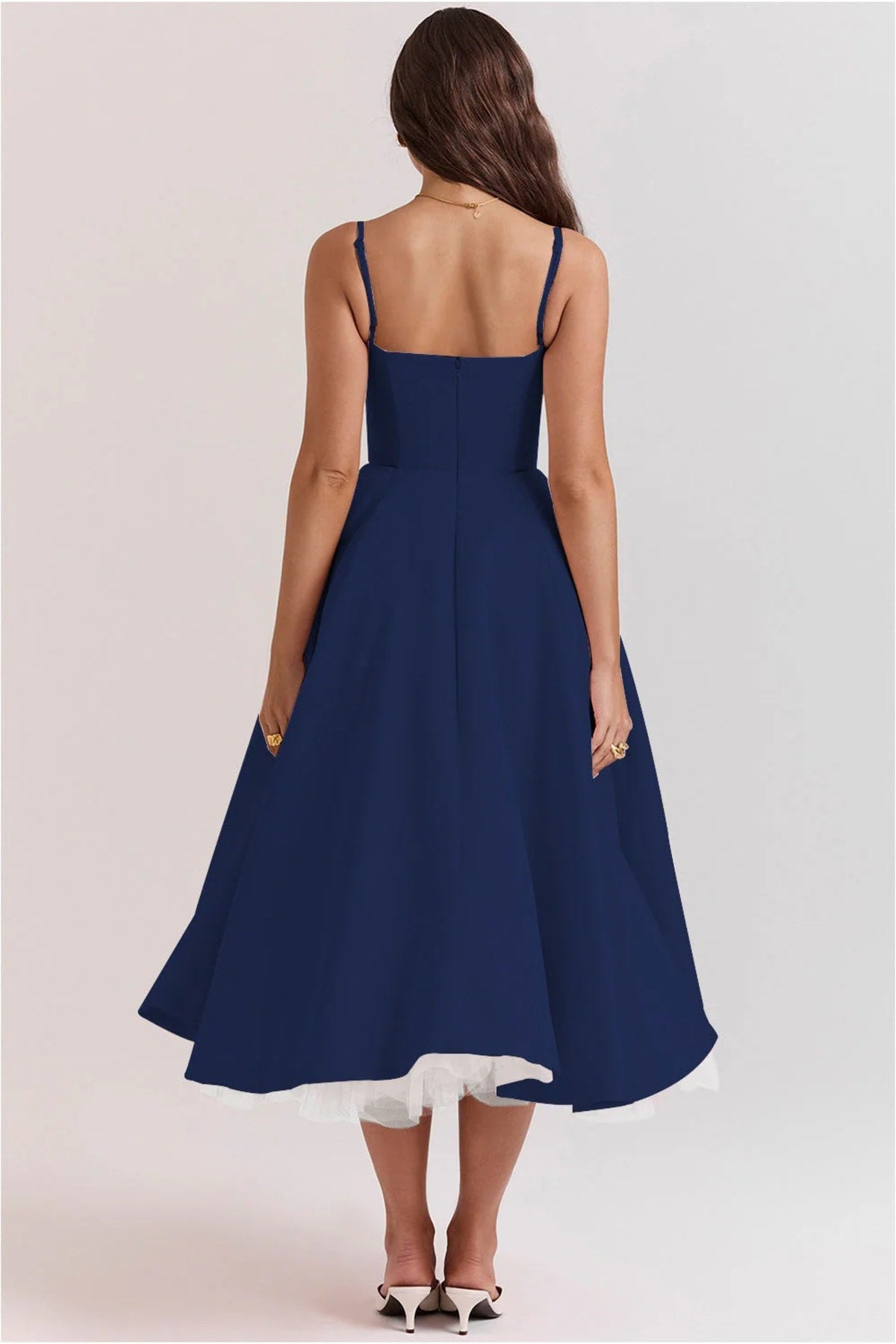 Woman in a midi dress with sweetheart neckline, full skirt, and spaghetti straps.