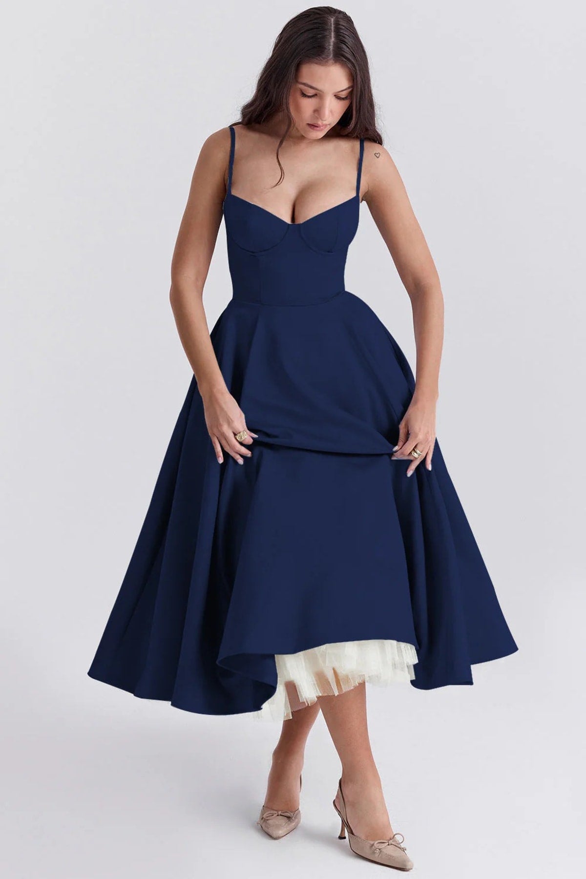 Woman in a midi dress with sweetheart neckline, full skirt, and spaghetti straps.