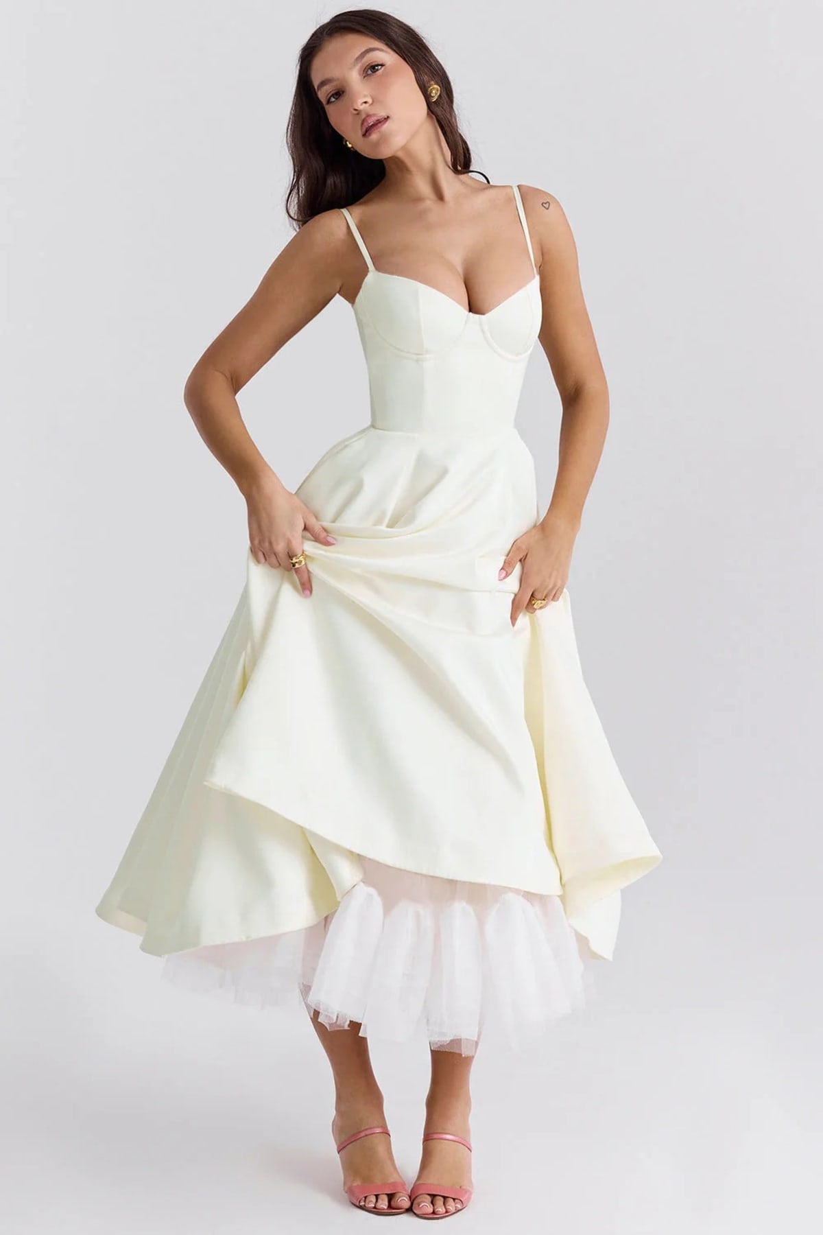Woman in a midi dress with sweetheart neckline, full skirt, and spaghetti straps.