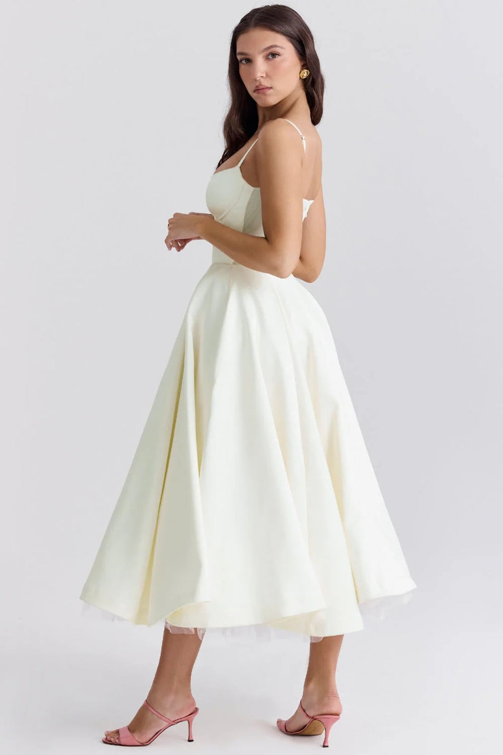 Woman in a midi dress with sweetheart neckline, full skirt, and spaghetti straps.