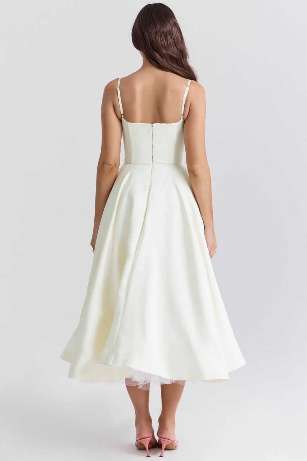 Woman in a midi dress with sweetheart neckline, full skirt, and spaghetti straps.