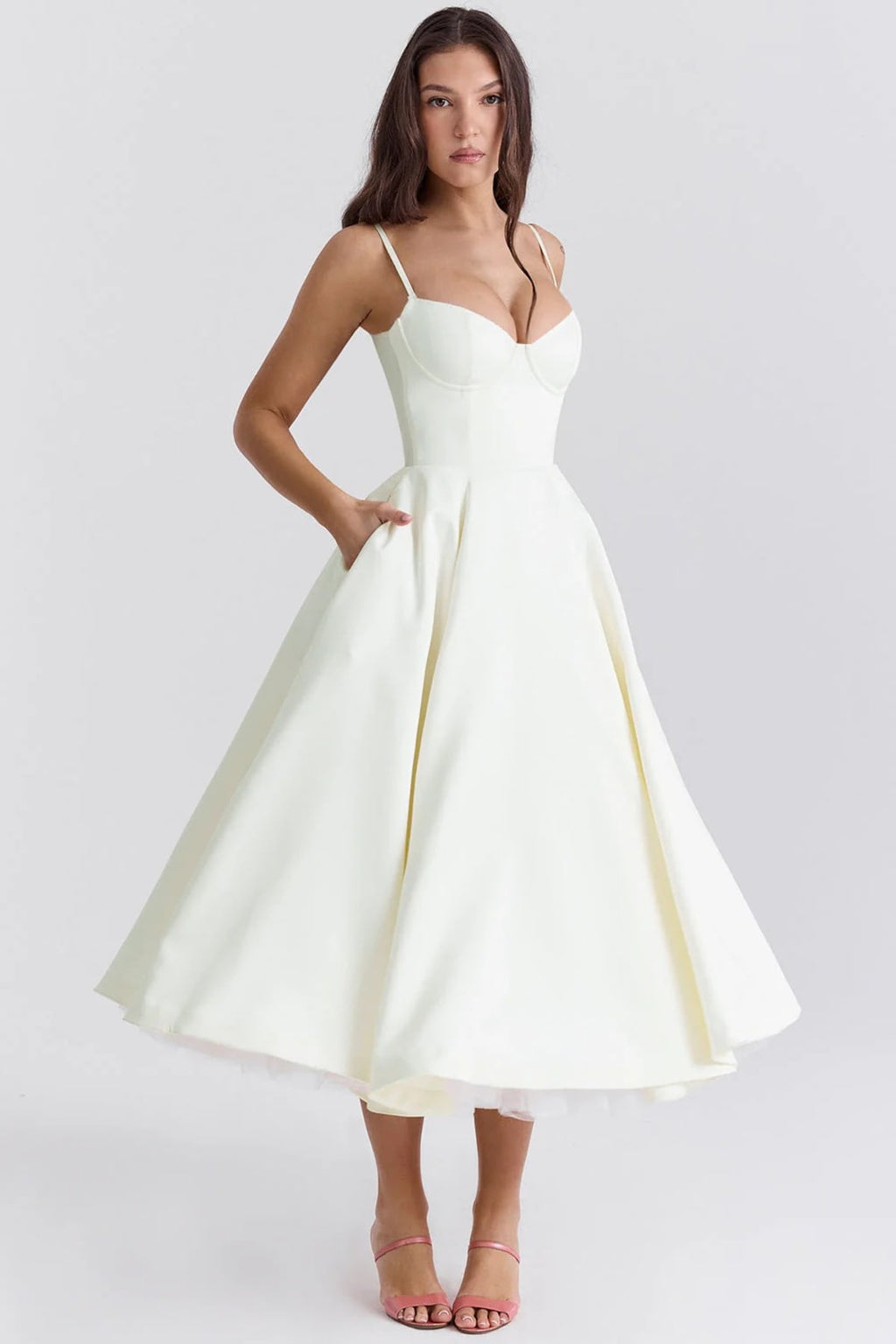 Woman in a midi dress with sweetheart neckline, full skirt, and spaghetti straps.