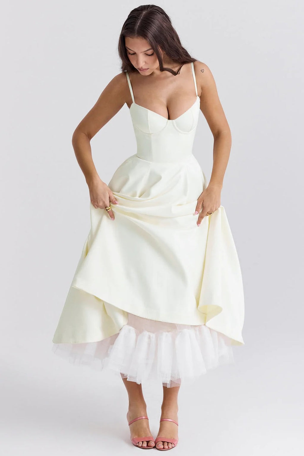 Woman in a midi dress with sweetheart neckline, full skirt, and spaghetti straps.