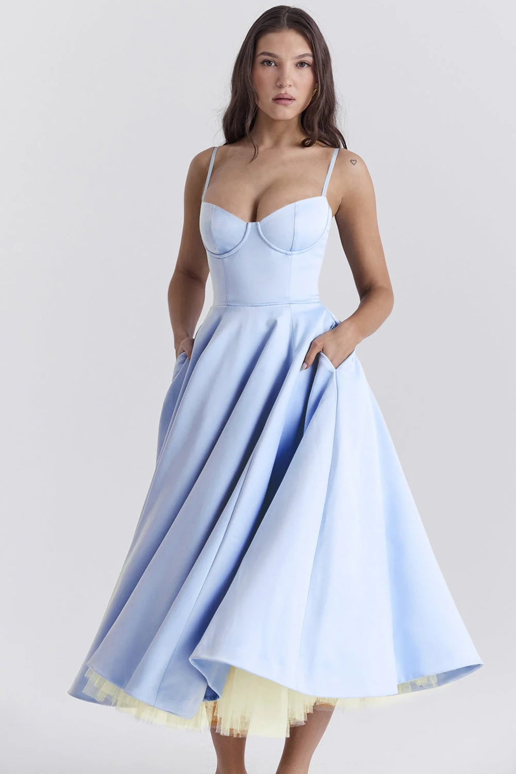 Woman in a midi dress with sweetheart neckline, full skirt, and spaghetti straps.