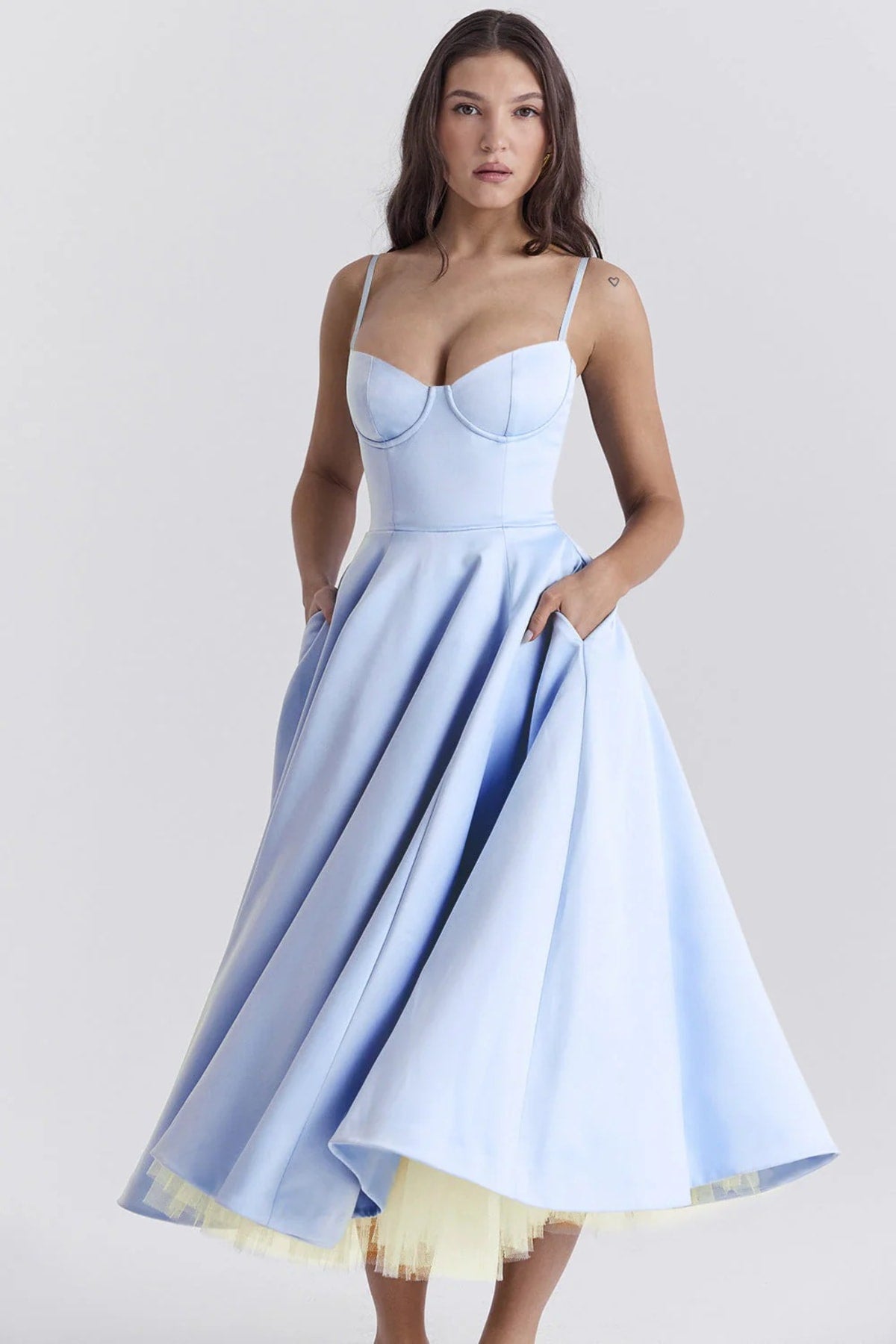 Woman in a midi dress with sweetheart neckline, full skirt, and spaghetti straps.