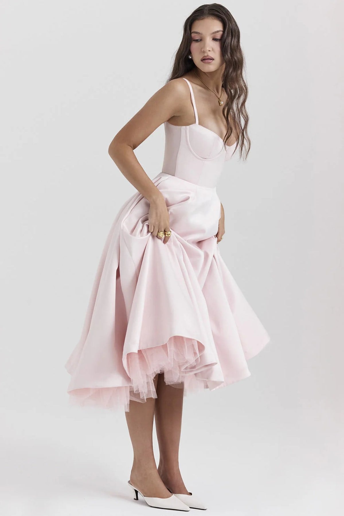 Woman in a midi dress with sweetheart neckline, full skirt, and spaghetti straps.
