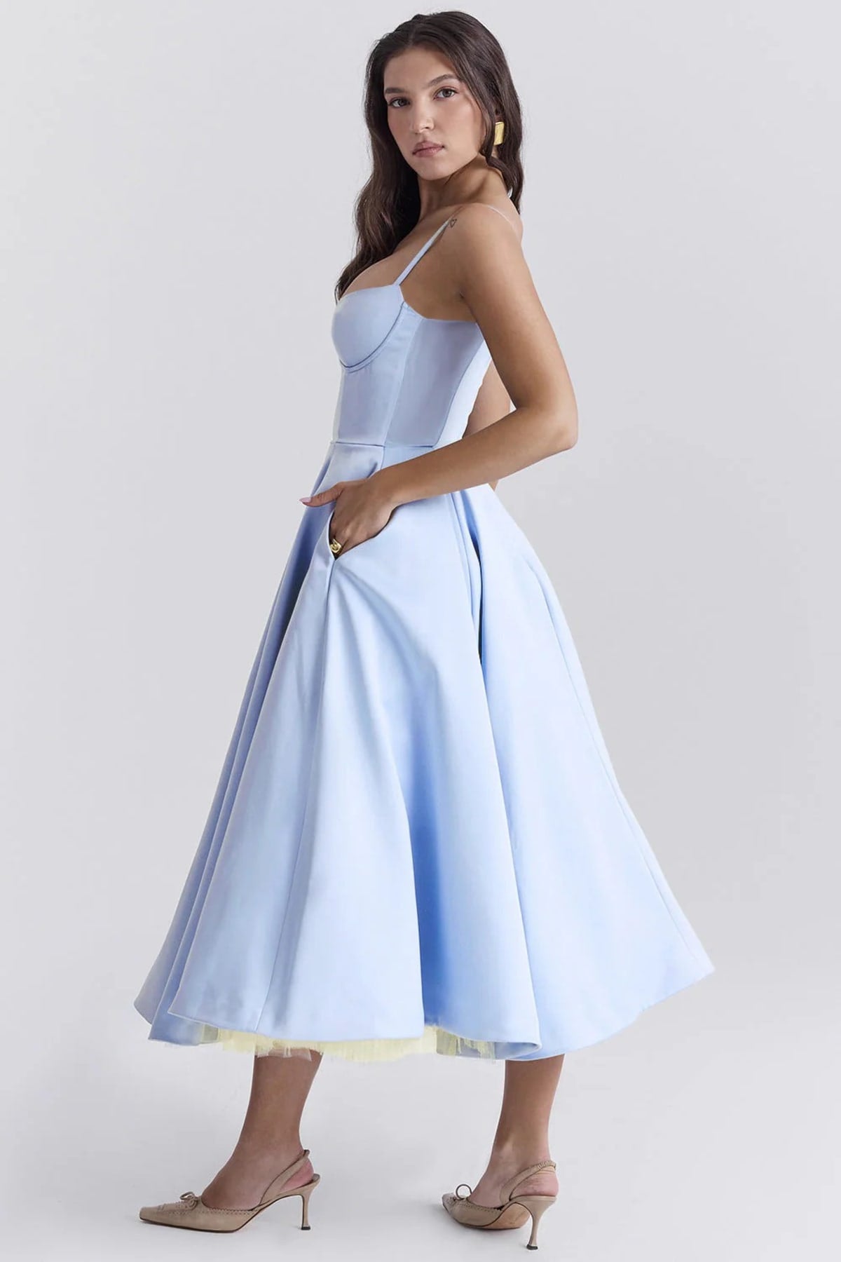 Woman in a midi dress with sweetheart neckline, full skirt, and spaghetti straps.