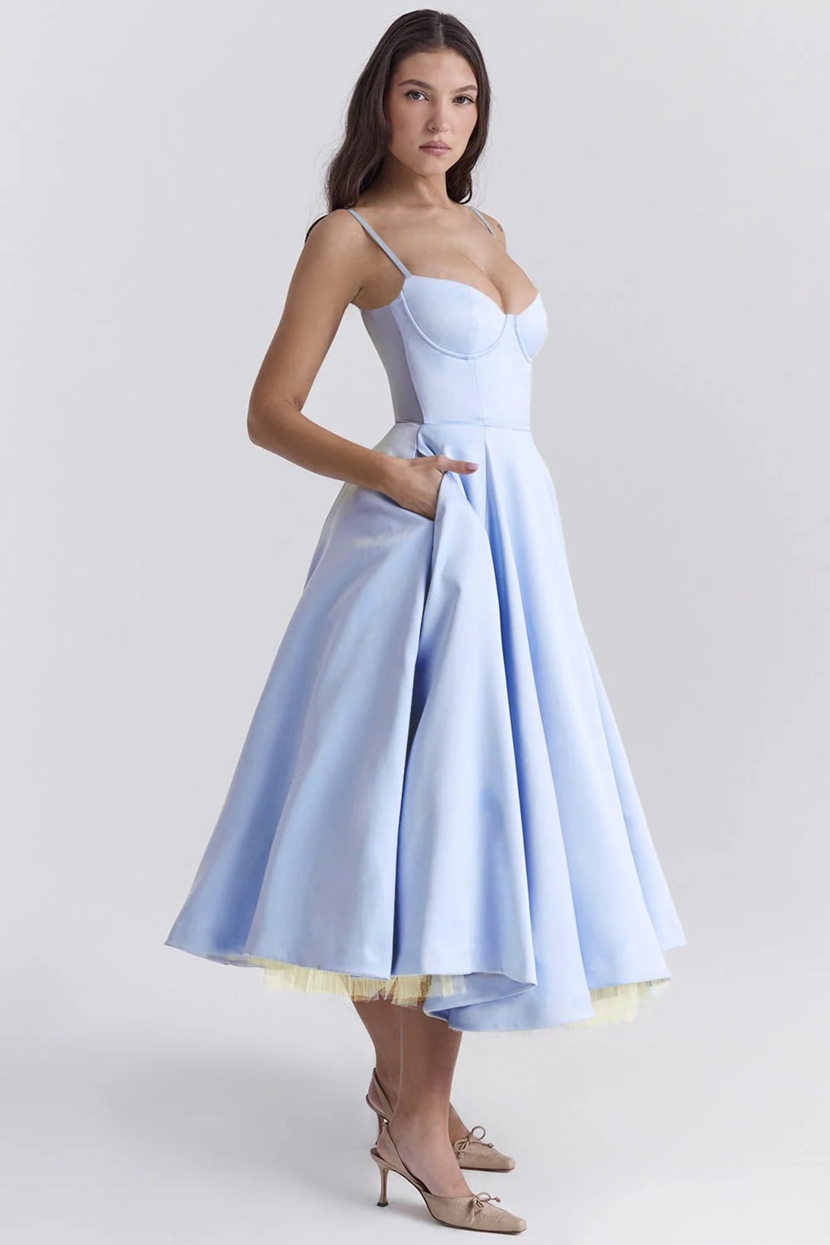 Woman in a midi dress with sweetheart neckline, full skirt, and spaghetti straps.
