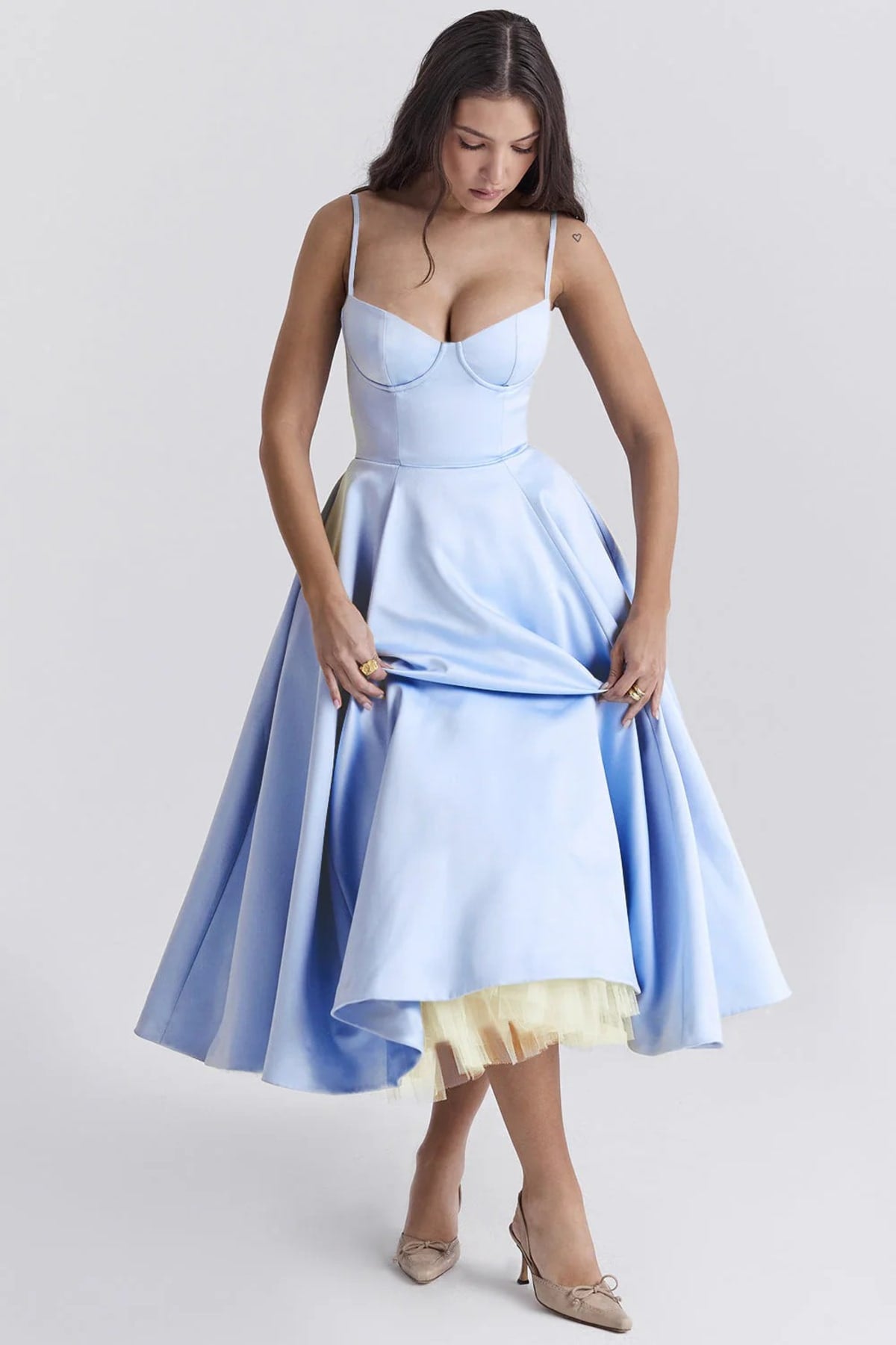 Woman in a midi dress with sweetheart neckline, full skirt, and spaghetti straps.
