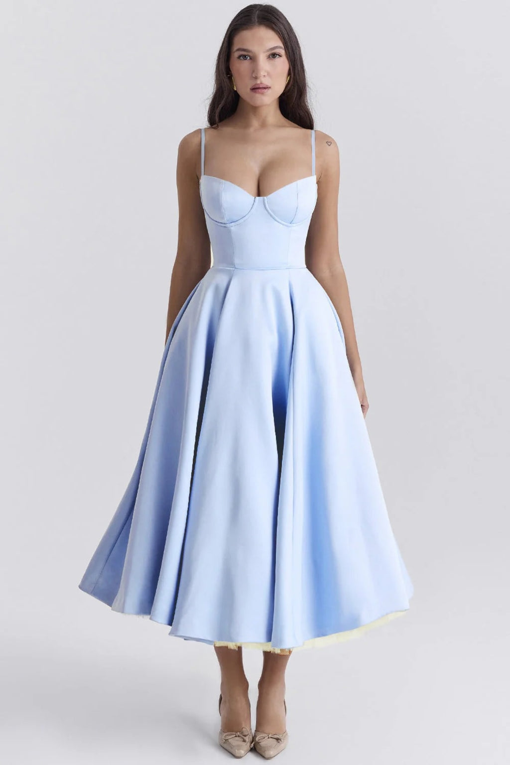 Woman in a midi dress with sweetheart neckline, full skirt, and spaghetti straps.