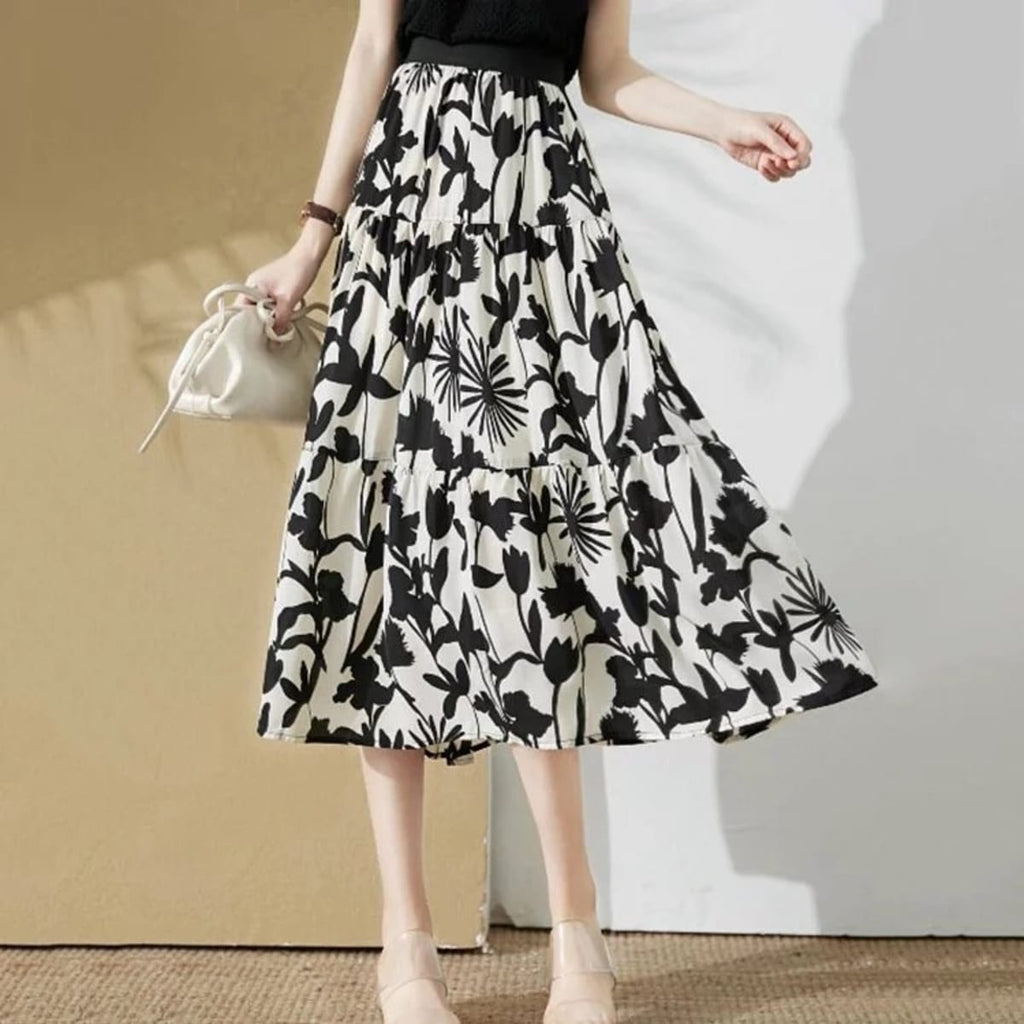 Woman wearing a floral tiered a-line midi skirt with sleeveless top.
