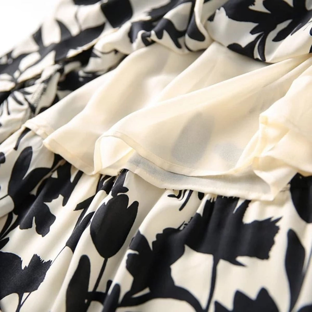 Woman wearing a floral tiered a-line midi skirt with sleeveless top.