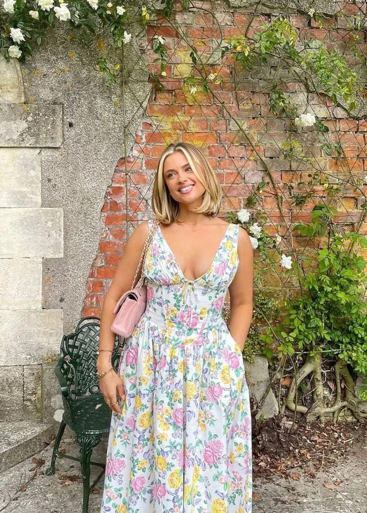 White midi dress with floral print, V-neckline, and pockets.