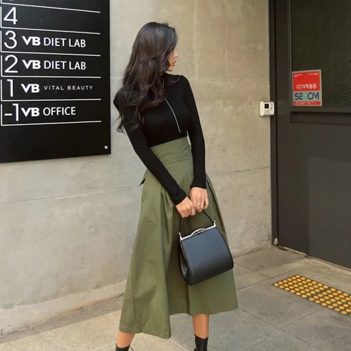 Woman wearing A-line midi wrap skirt with self-tie waist outdoors