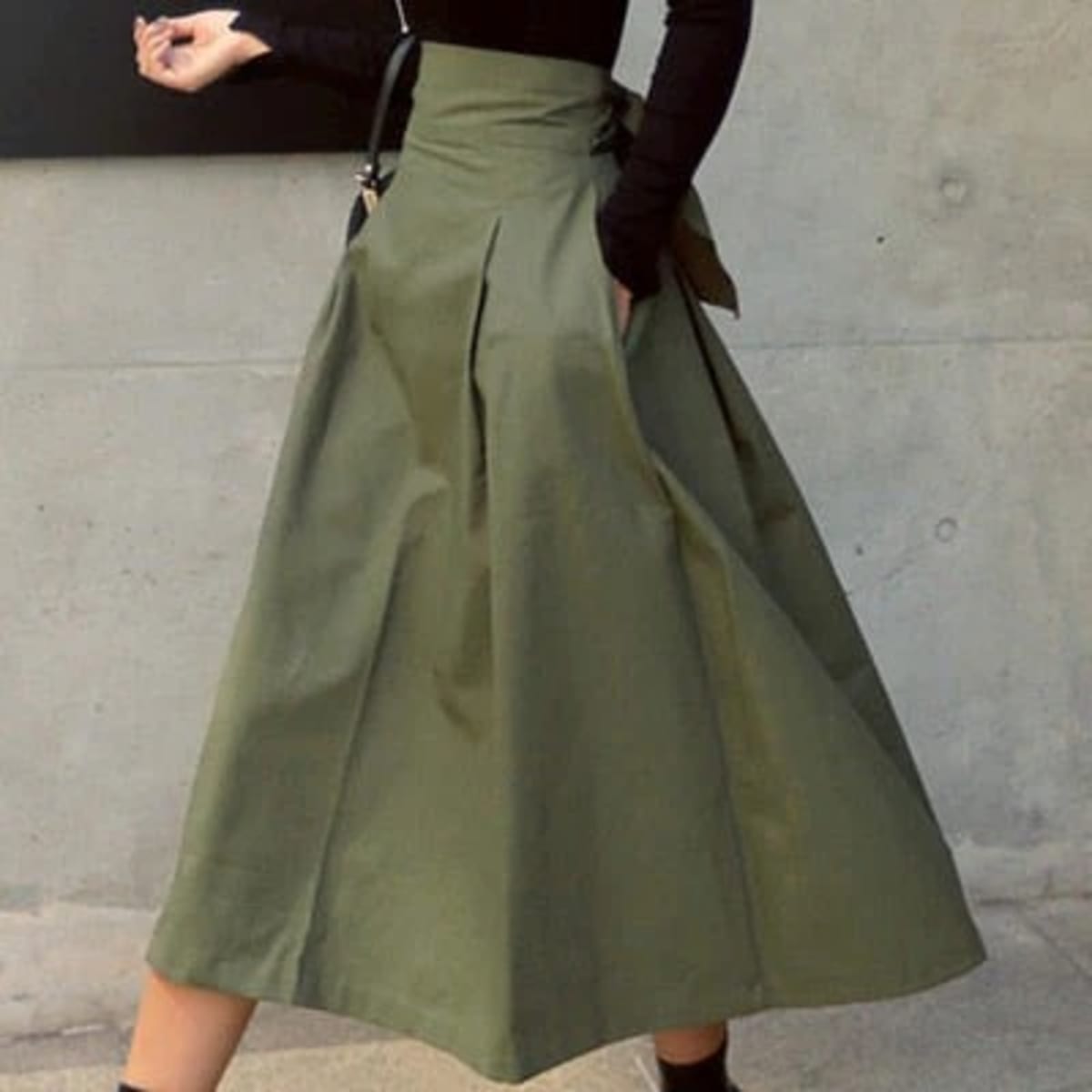 Woman wearing A-line midi wrap skirt with self-tie waist outdoors