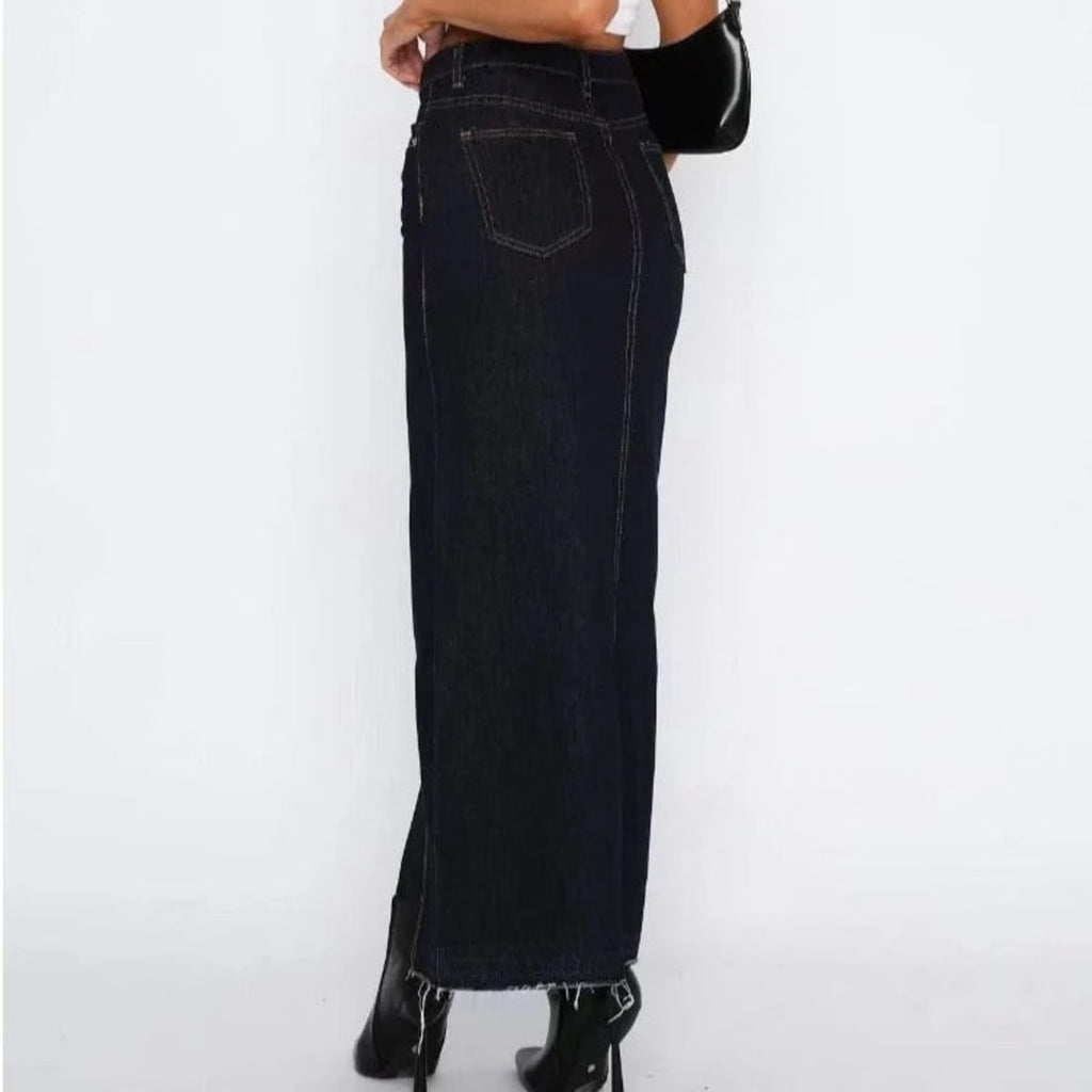 Woman wearing high-waisted denim maxi skirt with slit.
