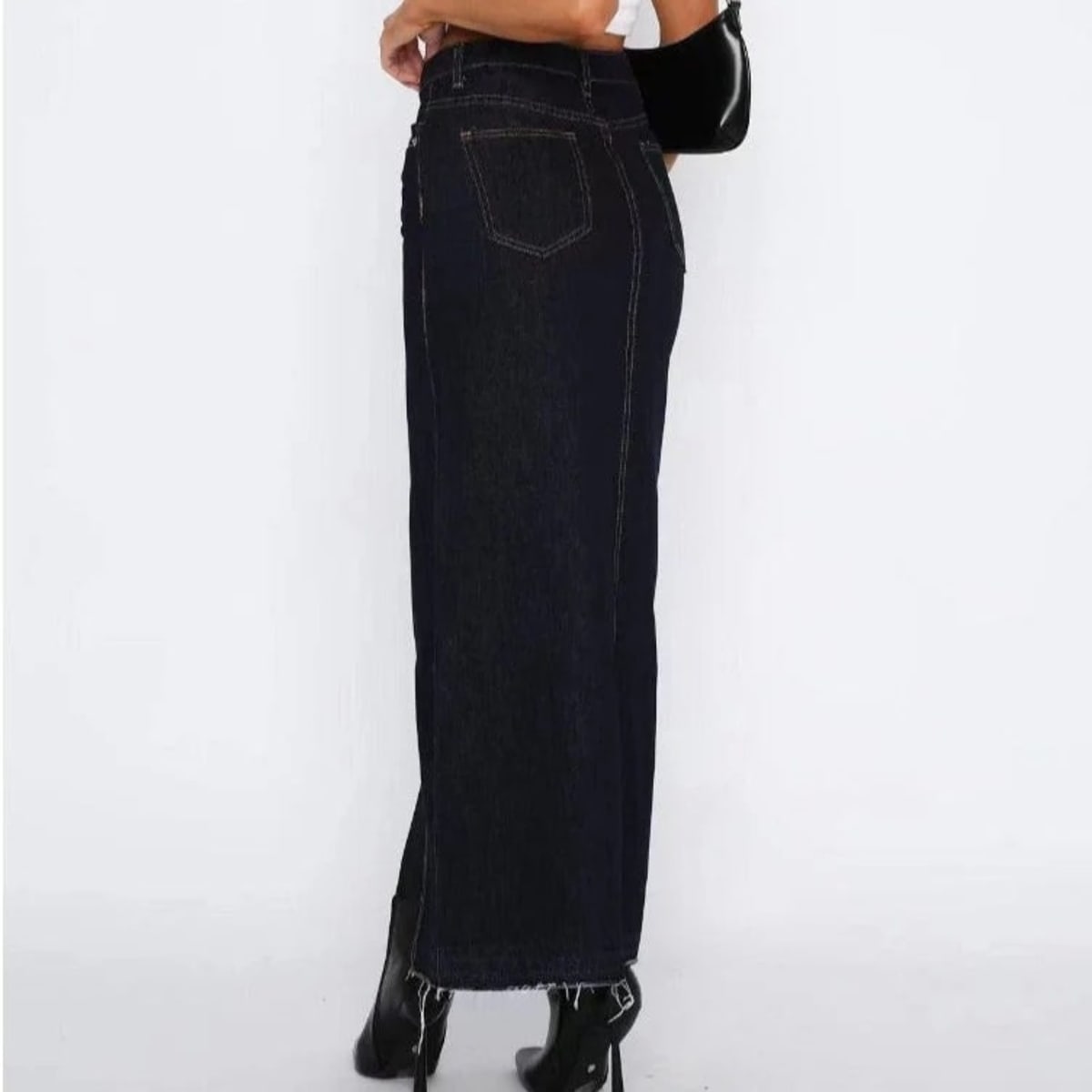 Woman wearing high-waisted denim maxi skirt with slit.