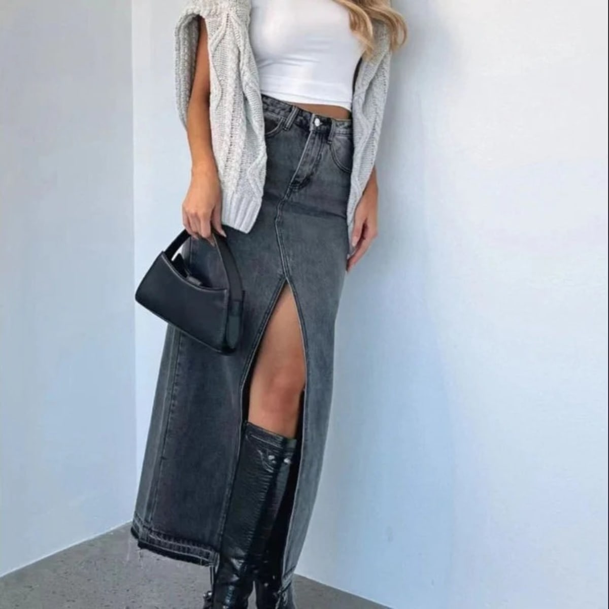 Woman wearing high-waisted denim maxi skirt with slit.