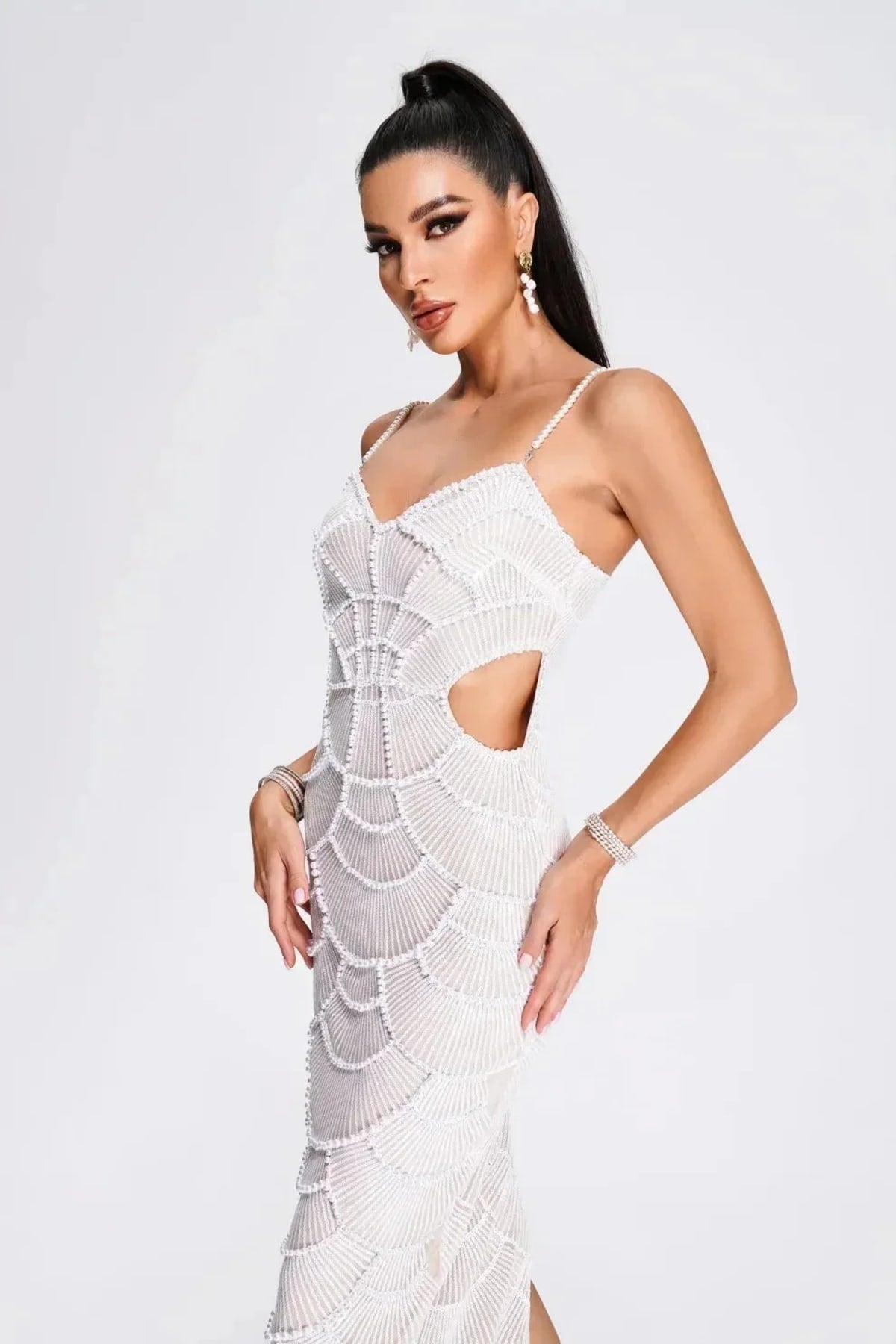 Woman in a beaded midi dress with side cut-outs and spaghetti straps.