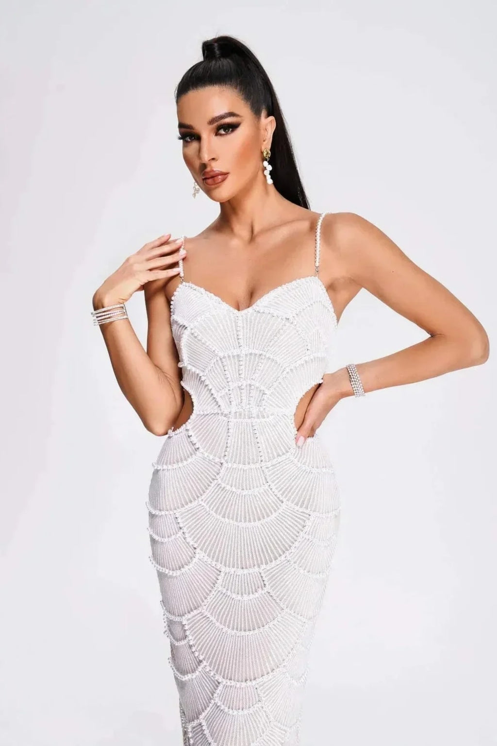 Woman in a beaded midi dress with side cut-outs and spaghetti straps.