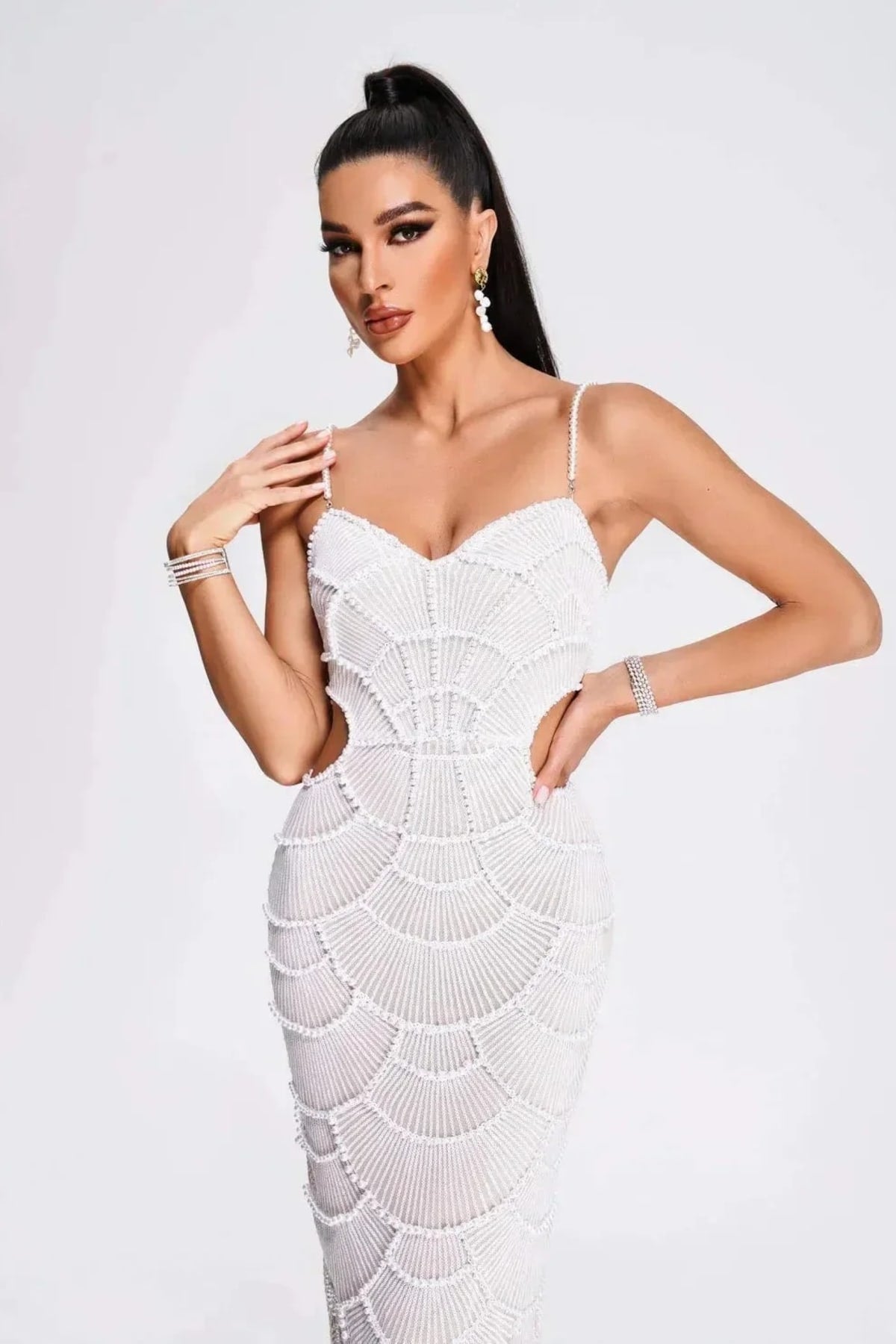 Woman in a beaded midi dress with side cut-outs and spaghetti straps.