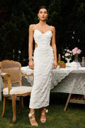 Woman in a beaded midi dress with side cut-outs and spaghetti straps.
