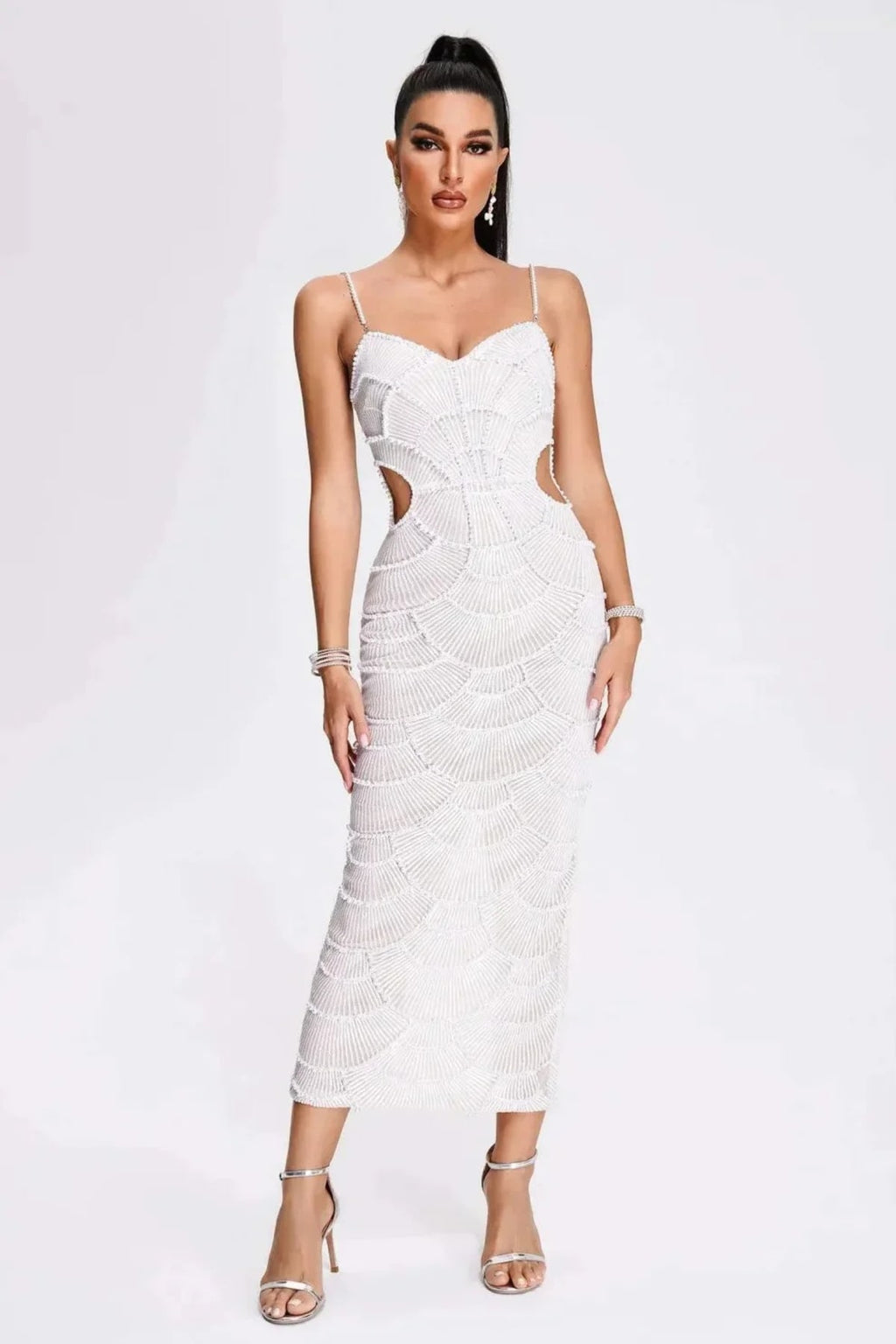 Woman in a beaded midi dress with side cut-outs and spaghetti straps.