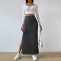 Woman wearing ribbed knit maxi skirt with a side slit.