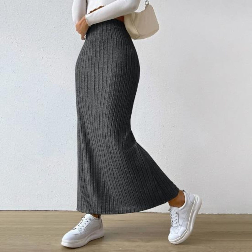 Woman wearing ribbed knit maxi skirt with a side slit.