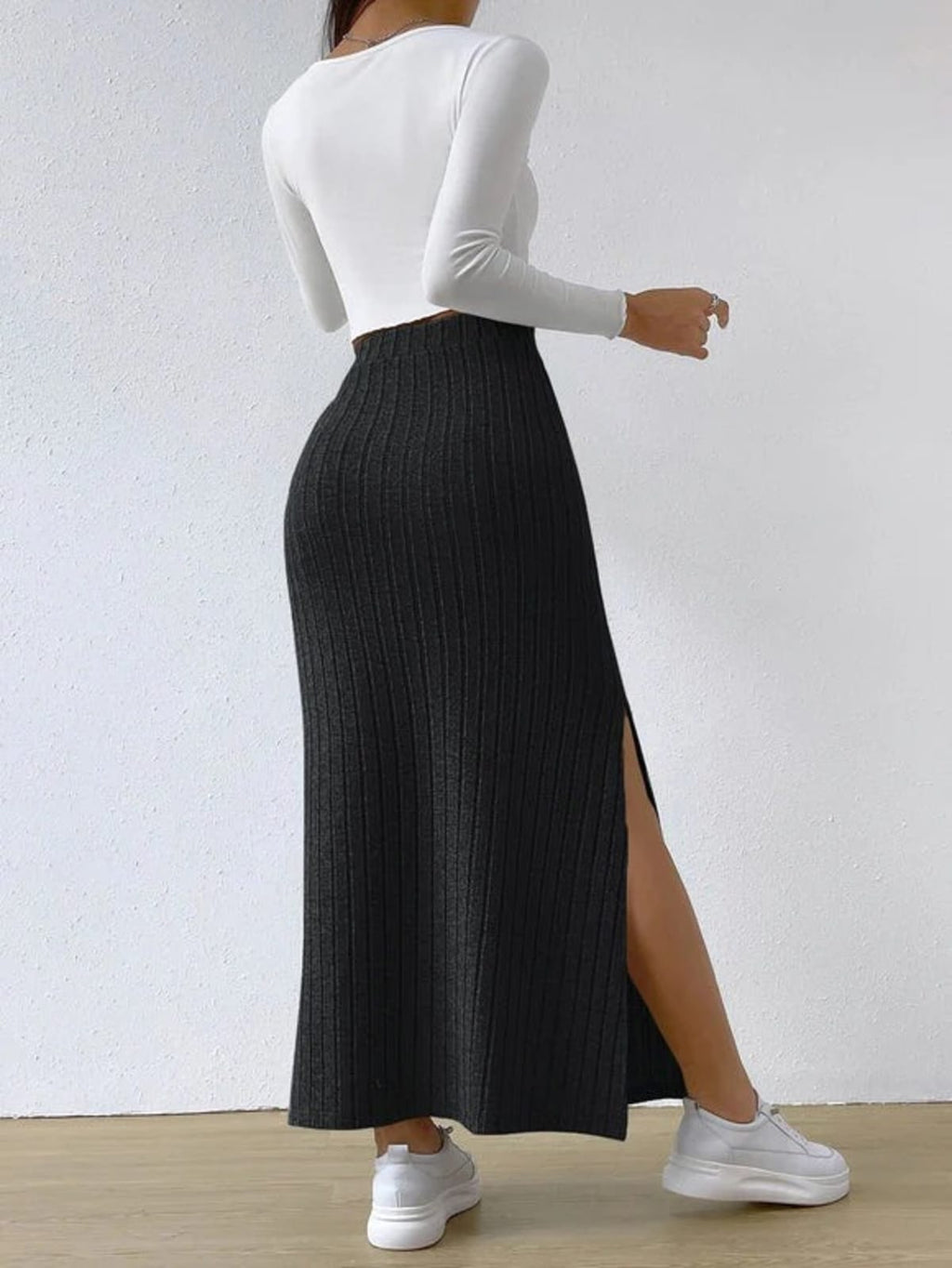 Woman wearing ribbed knit maxi skirt with a side slit.
