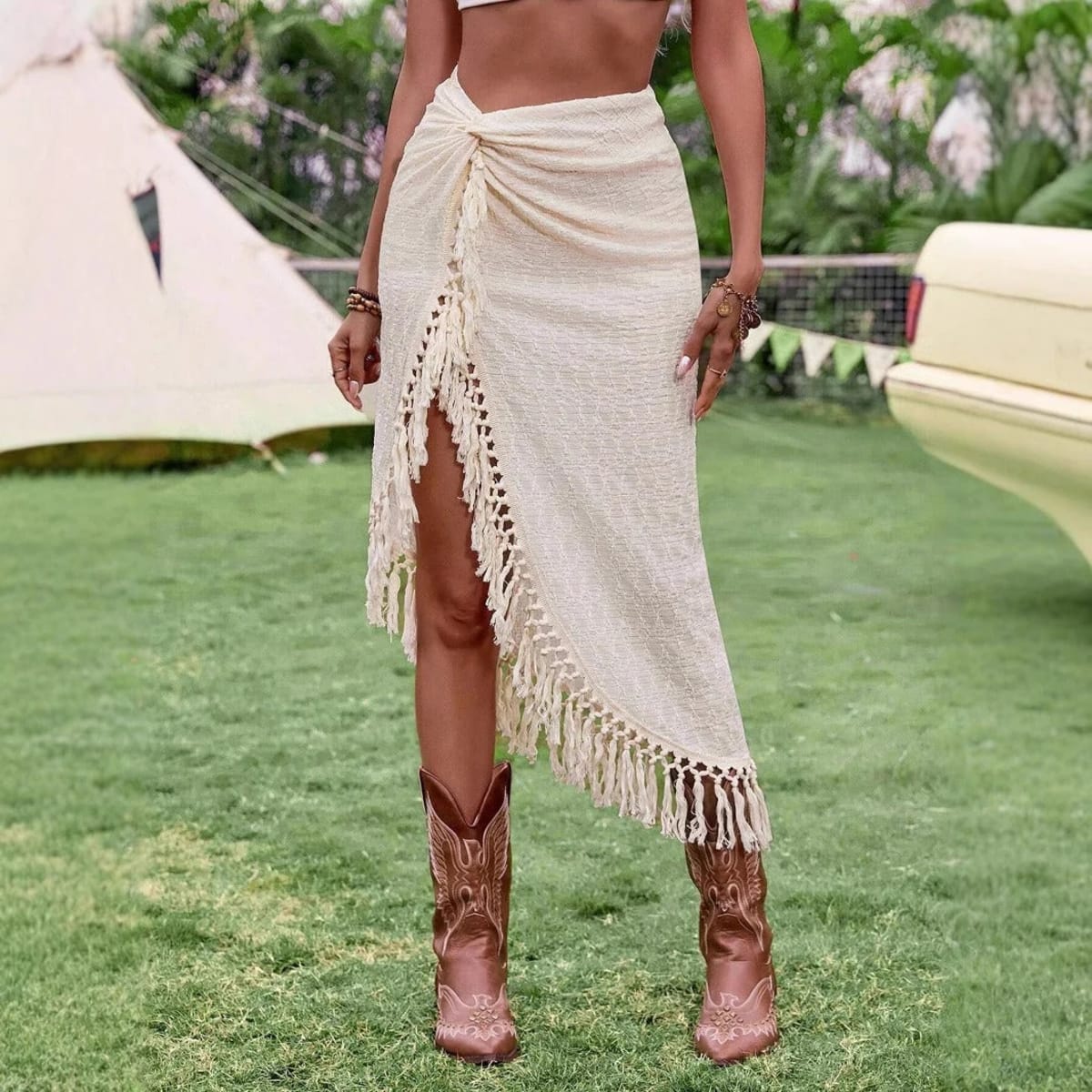 Cream midi skirt with fringe trim and high slit.