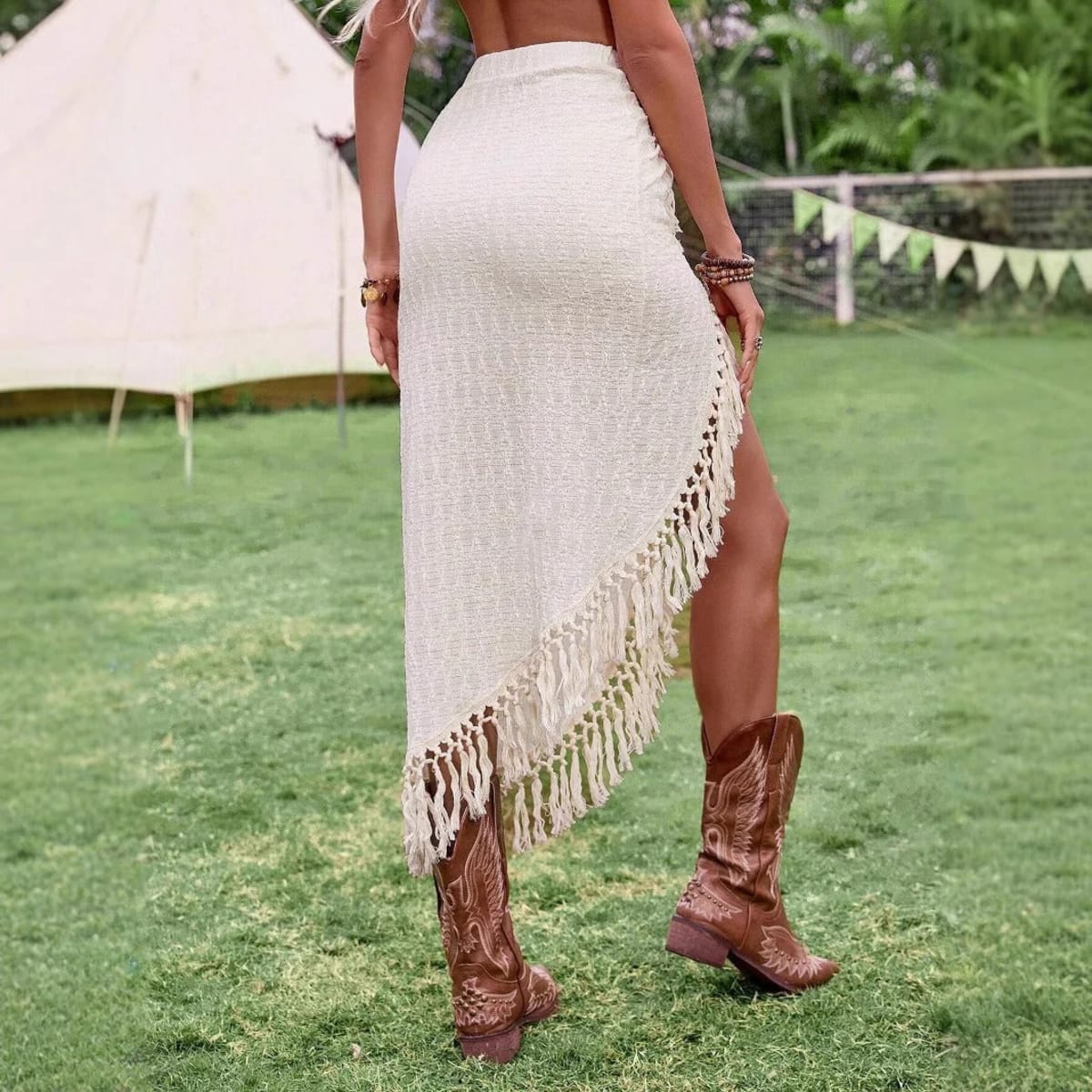 Cream midi skirt with fringe trim and high slit.