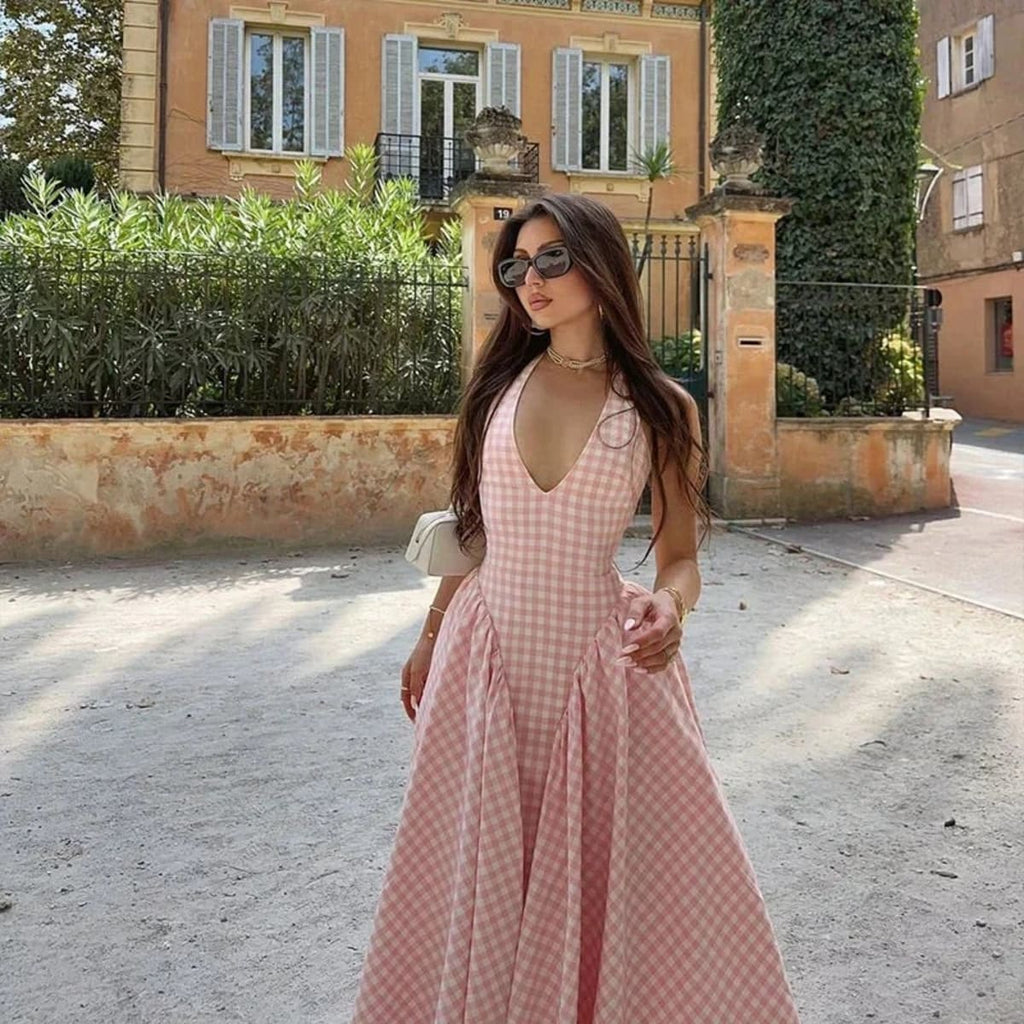 Woman wearing a gingham midi dress with V-neck and pleated skirt.