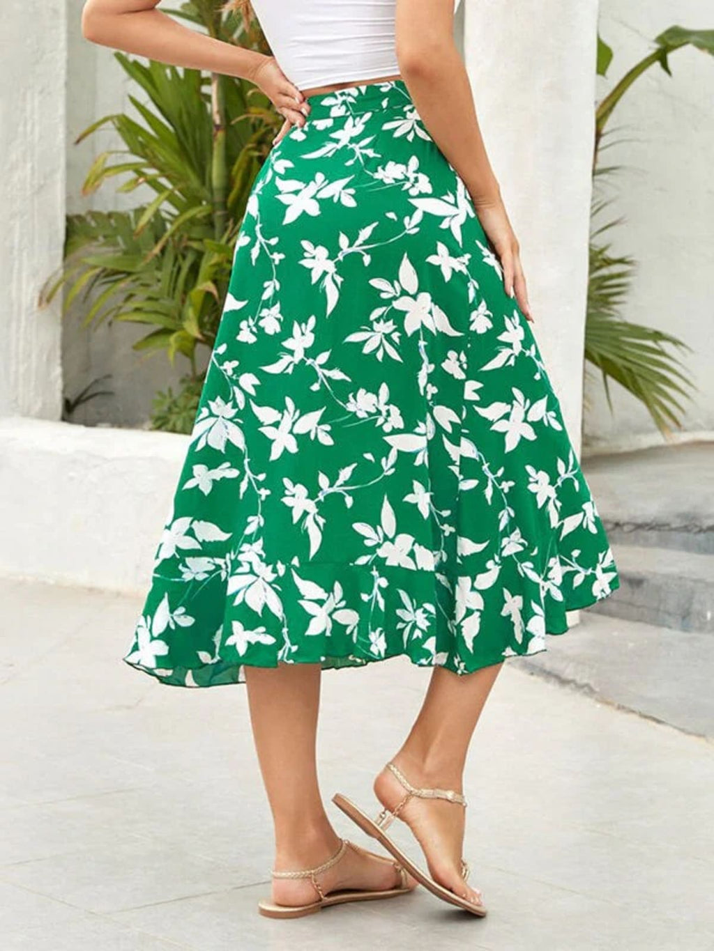 Woman wearing a floral wrap midi skirt with ruffled hem.