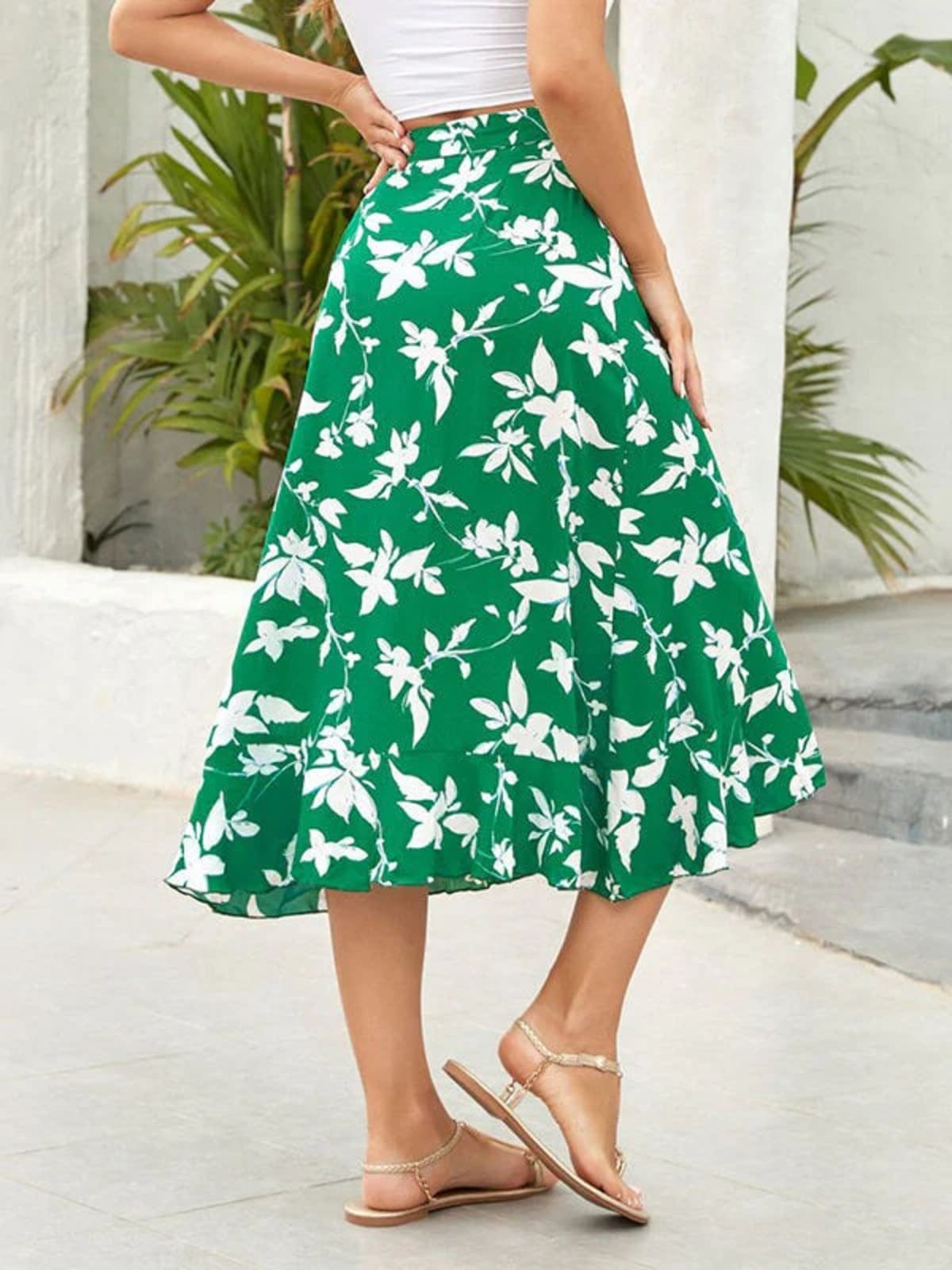 Woman wearing a floral wrap midi skirt with ruffled hem.