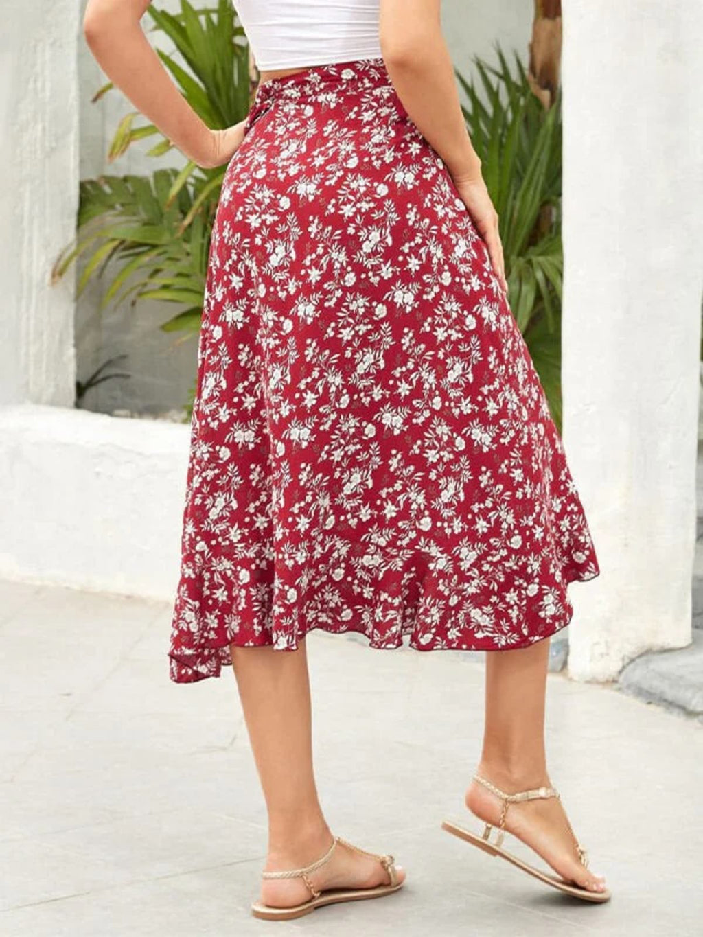 Woman wearing a floral wrap midi skirt with ruffled hem.